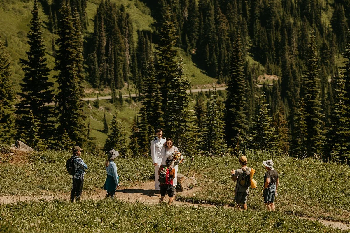 Elopement ceremony on a mountain trail with hikers and guests gathered nearby in Washington