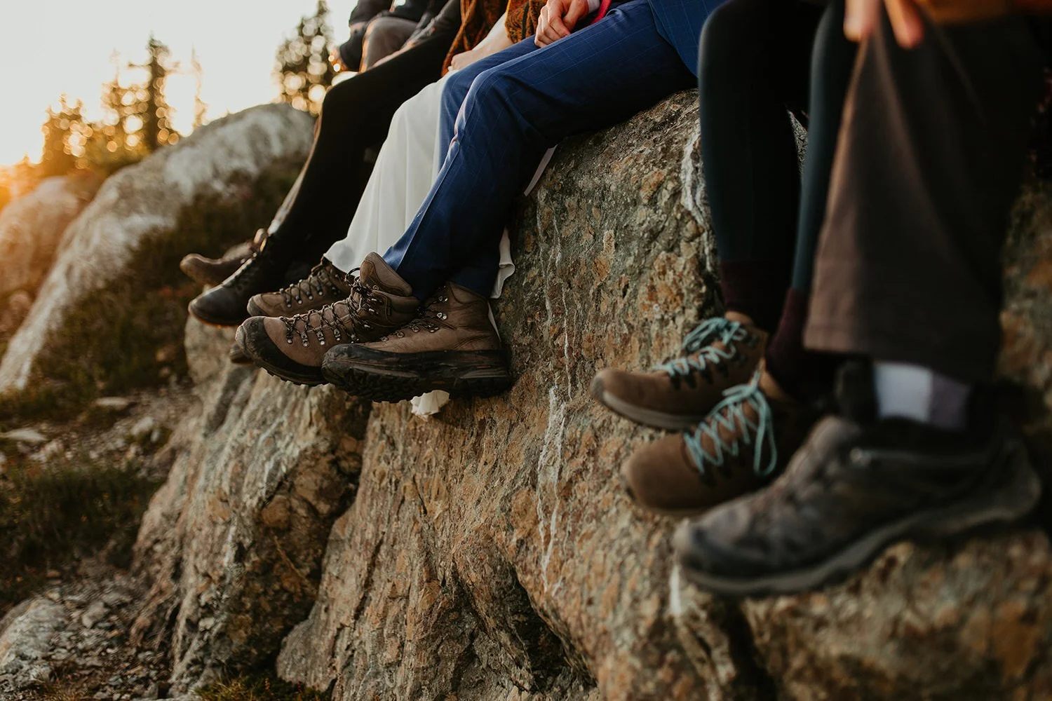 Close-up of hiking boots worn by elopement guests sitting on a rocky ledge at sunset