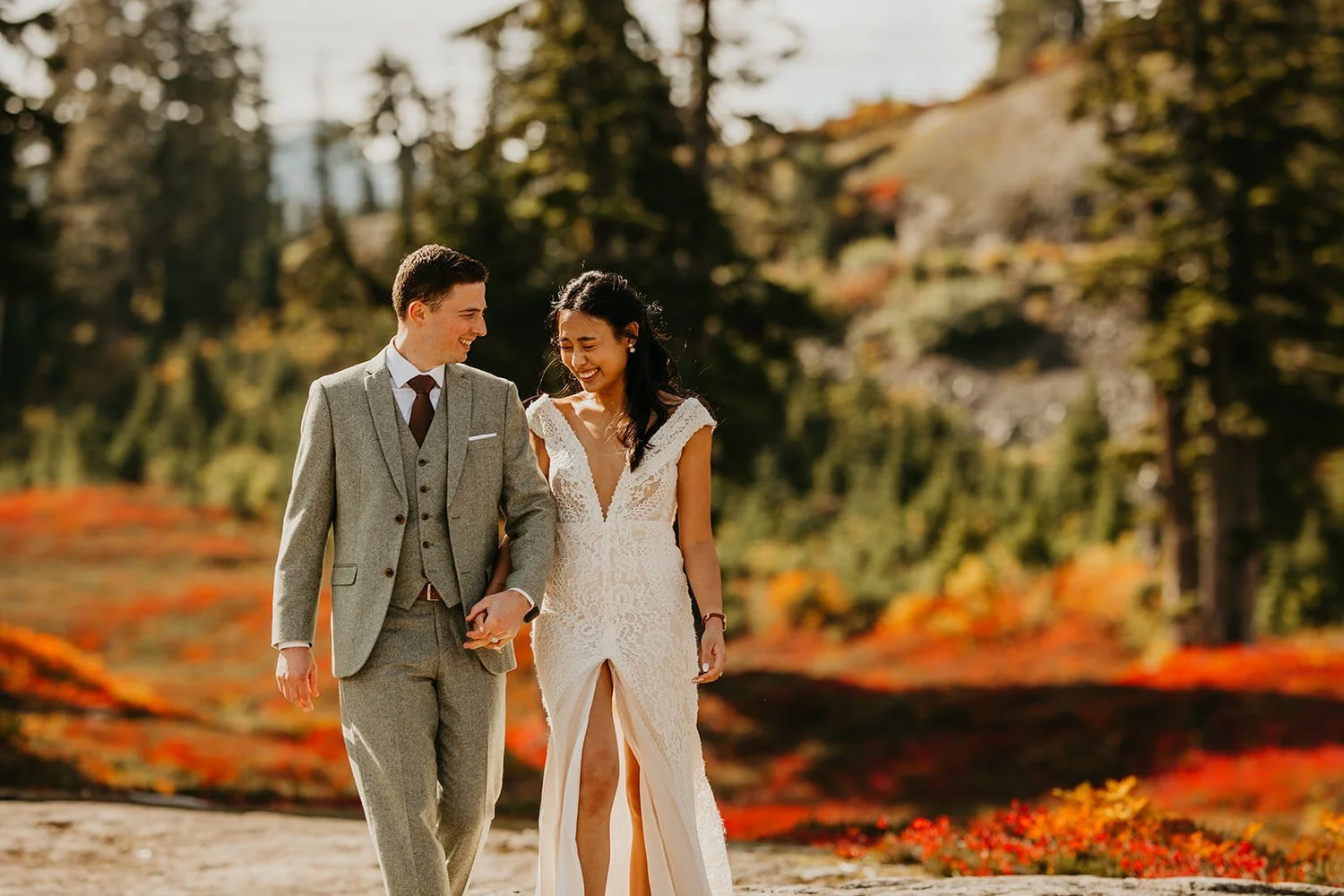 Eloping couple walking hand in hand through autumn colors in the North Cascades during fall foliage season
