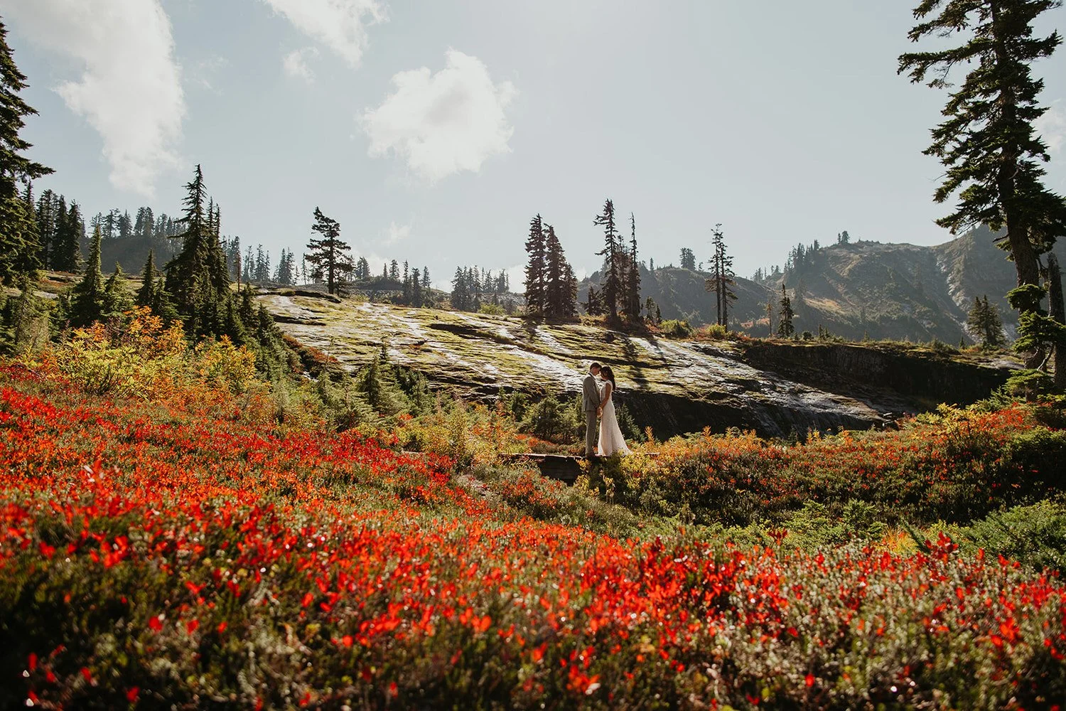 Family ceremony on a stone overlook platform with fog rolling over the surrounding peaks