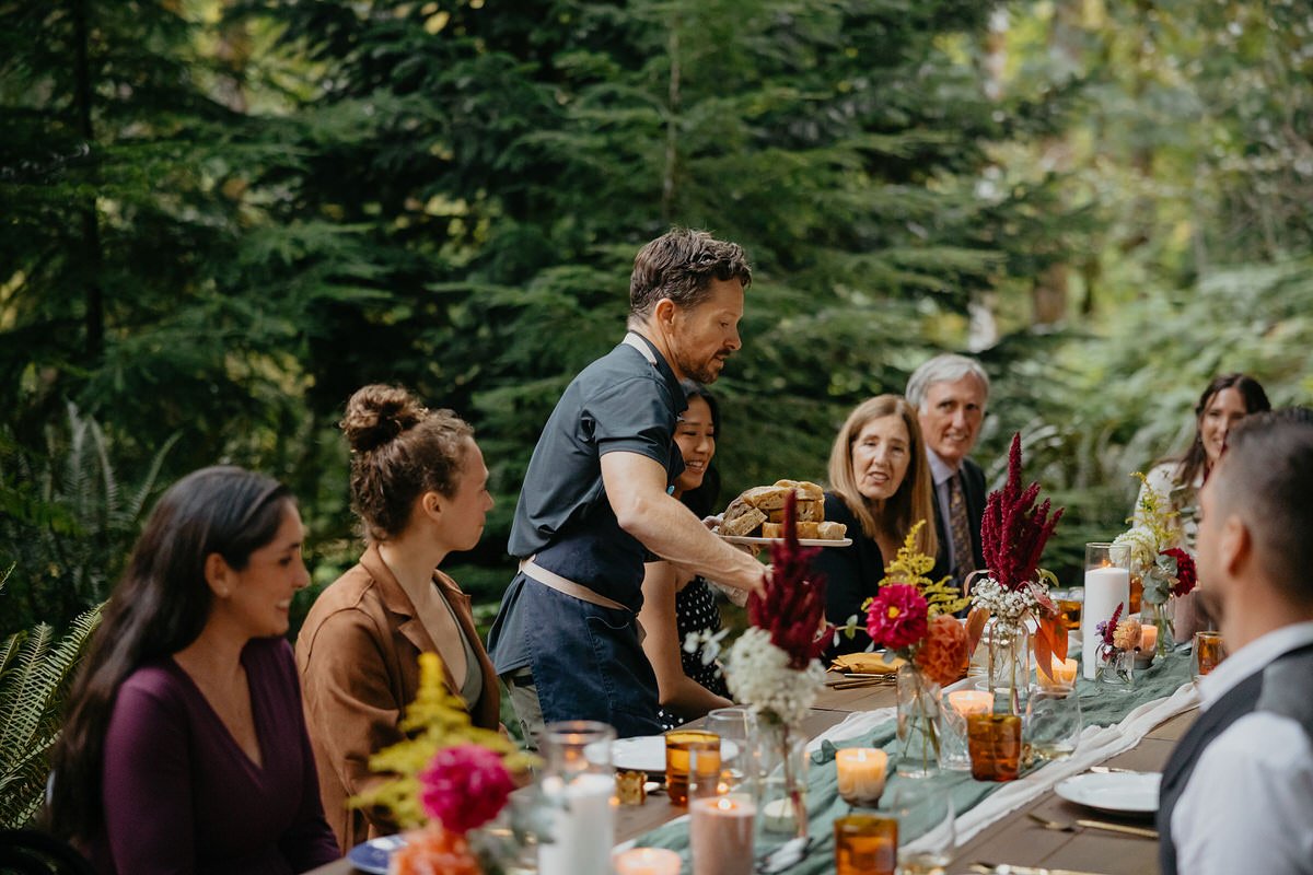 Private chef serving a candlelit dinner for elopement guests at a forest cabin in Washington.