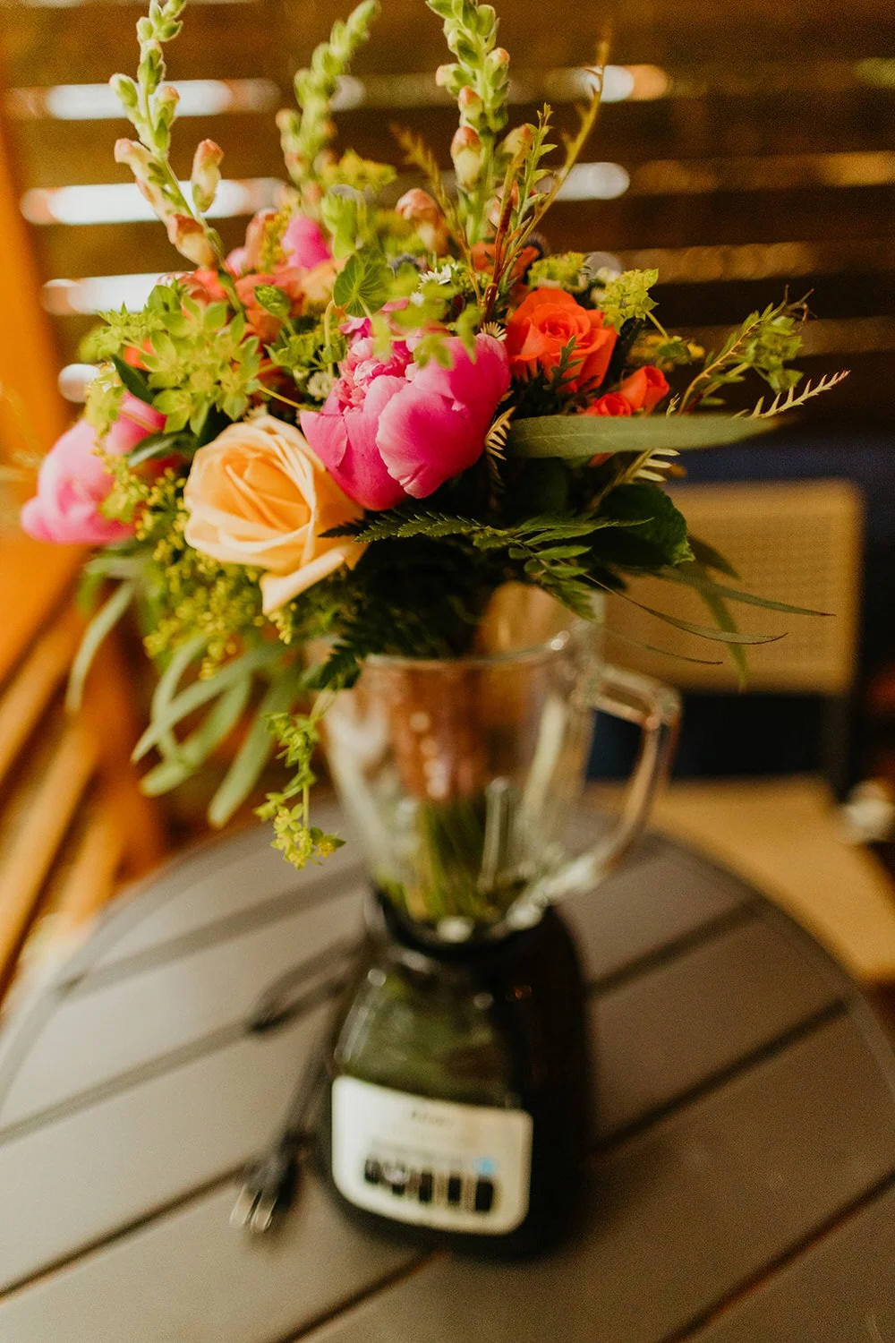 Lush floral elopement bouquet with greenery and blooms arranged on a wooden surface