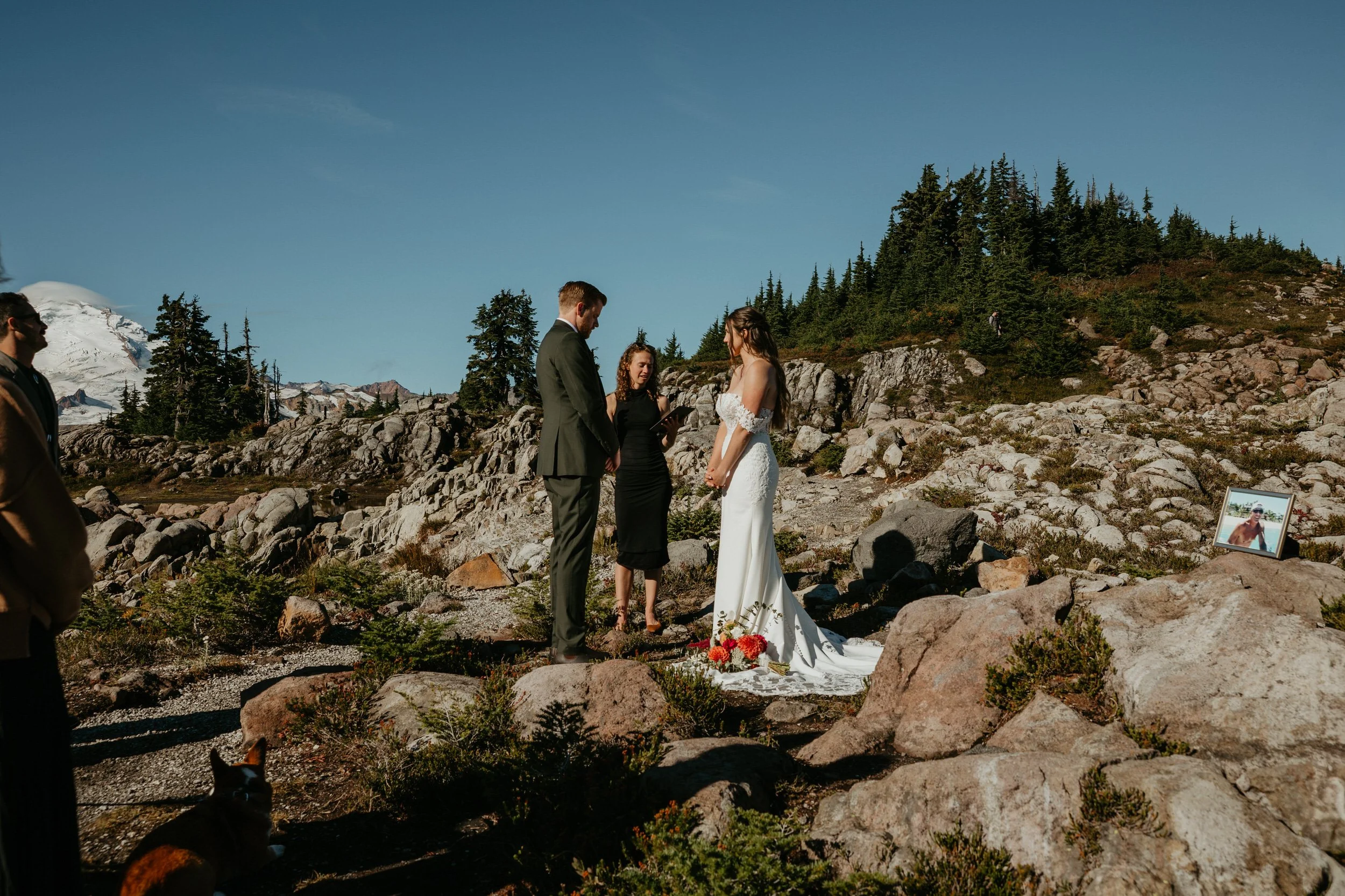 Outdoor mountain elopement ceremony with family gathered on a rocky overlook