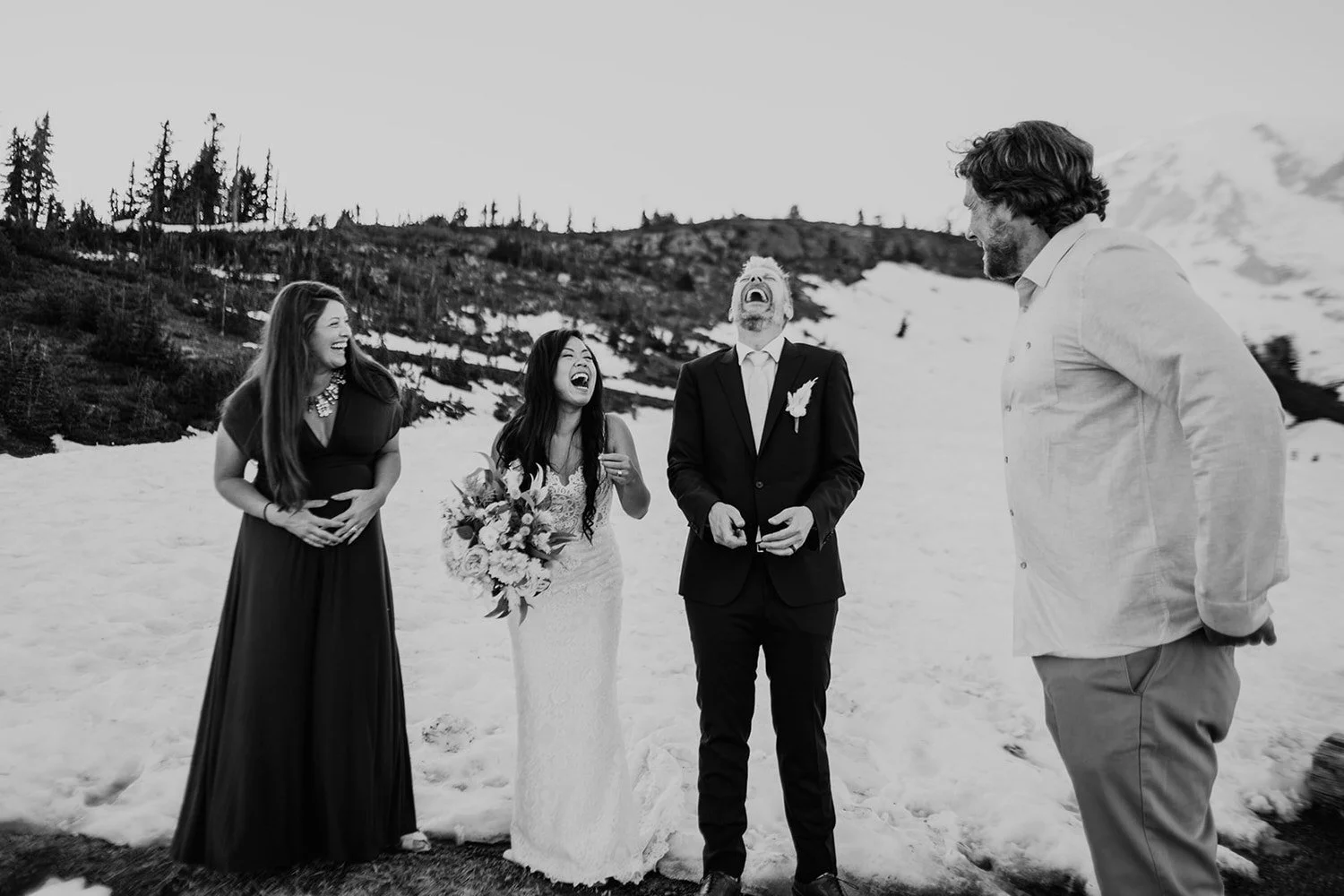 Couple laughing with guests during an elopement in a snowy mountain setting