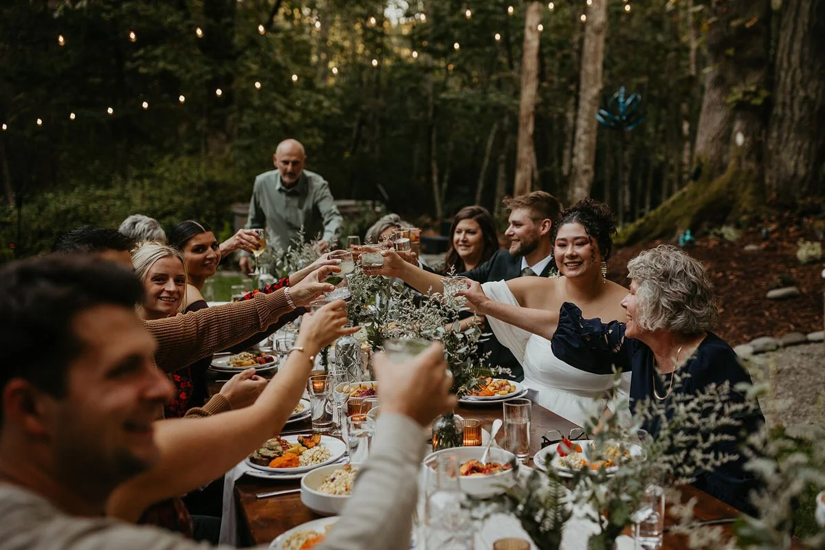 Outdoor dinner reception under string lights in a forest after a Washington micro wedding