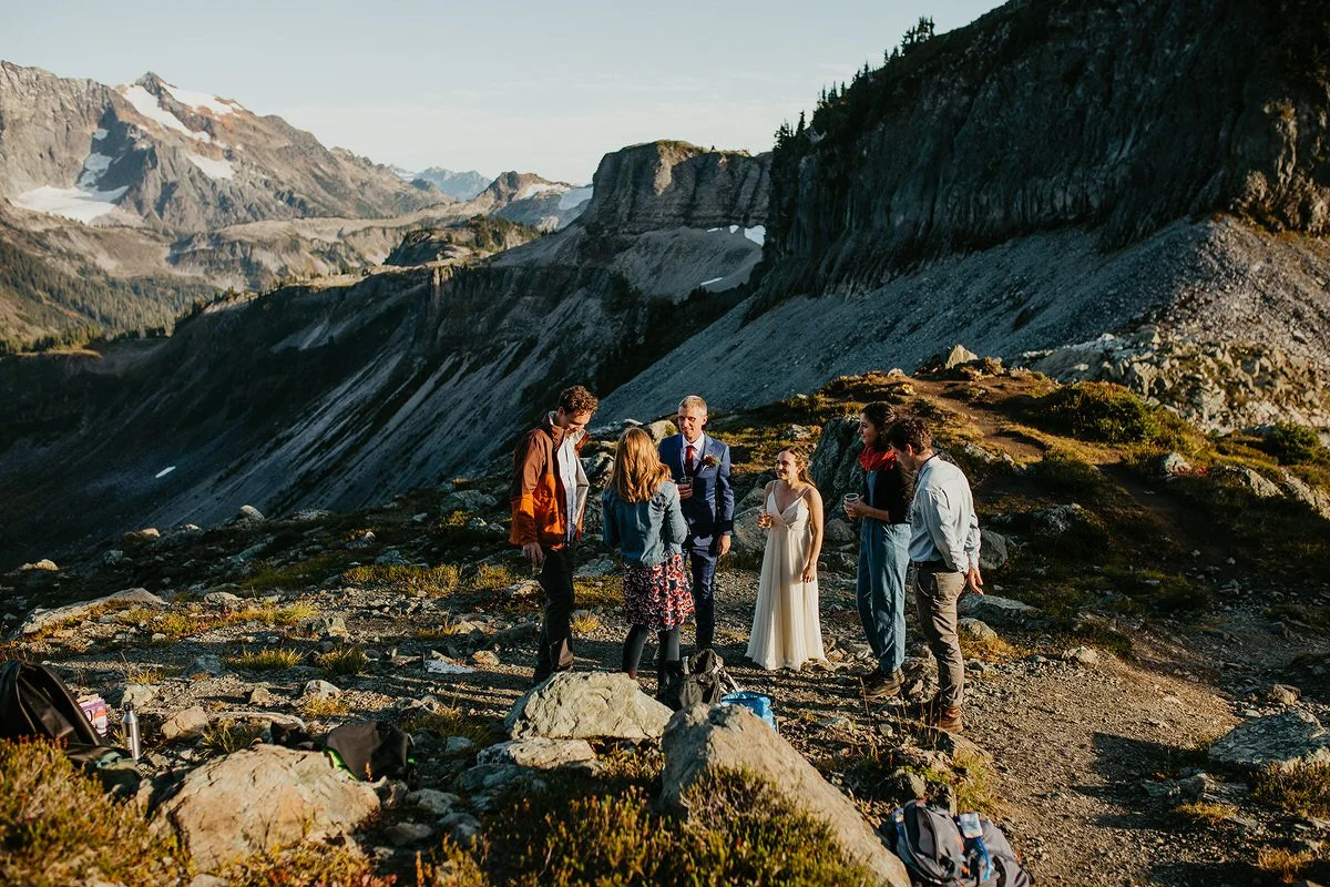 Couple hiking with guests along a mountain ridge during a Washington adventure elopement.