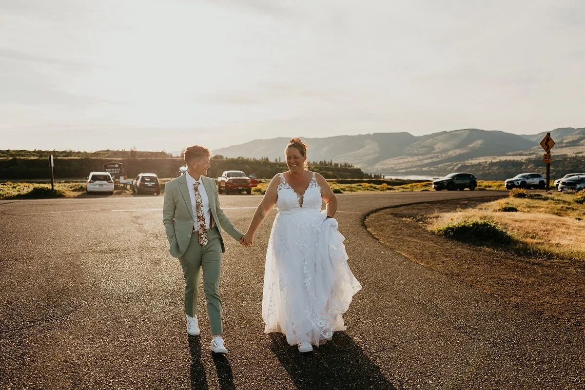 Couple walking hand in hand along a road at sunset with cars nearby in Washington