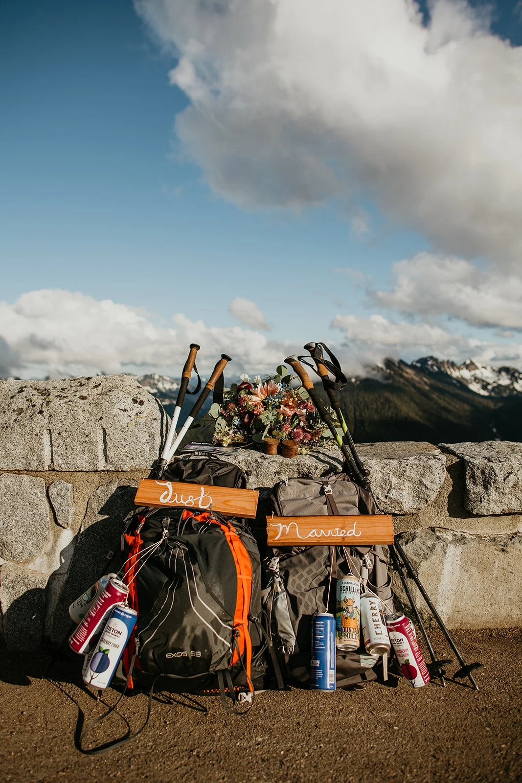Backpacking and elopement gear arranged on a mountain summit, including hiking packs, boots, and adventure essentials.