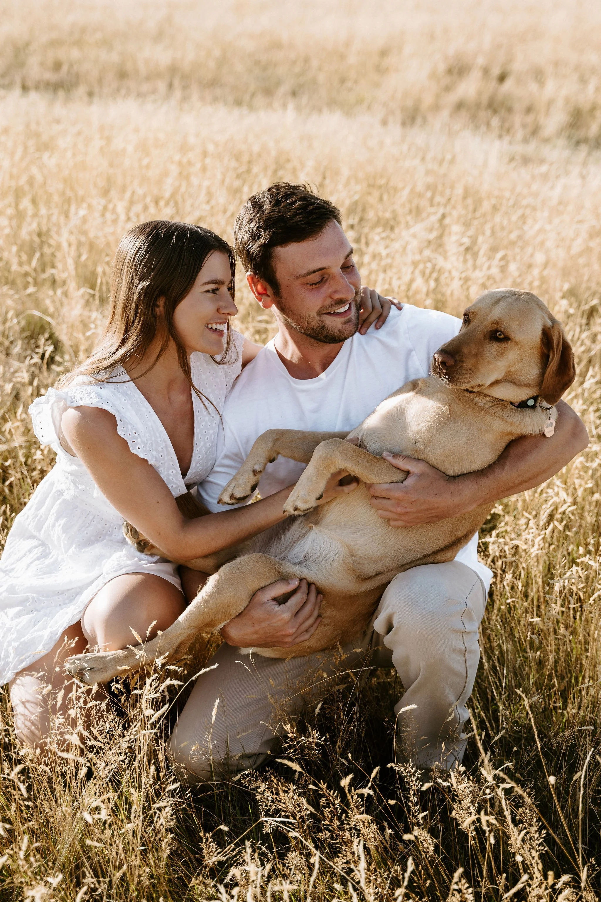 couple holding their dog for family portrait
