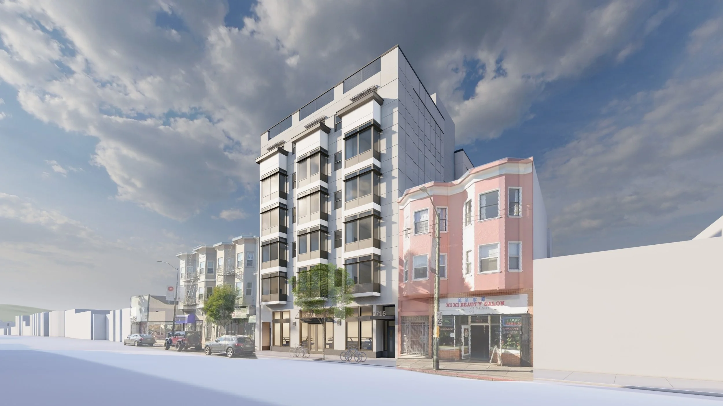 A modern multi-story building with large glass windows, situated on a city street with trees and parked cars, with other colorful buildings and a partly cloudy sky in the background.