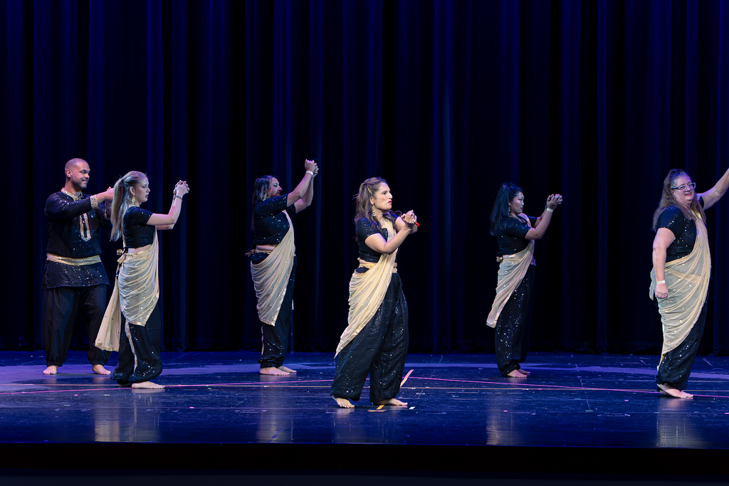 Adult dance group in stylish royal blue costumes on stage Spring showcase