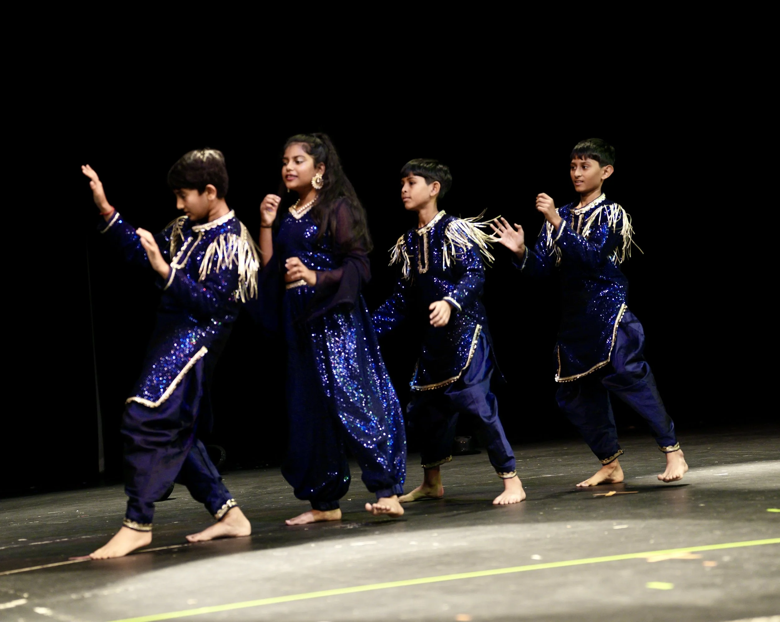 Bollywood teen dance class performing confidently under stage lights at Fall Recital