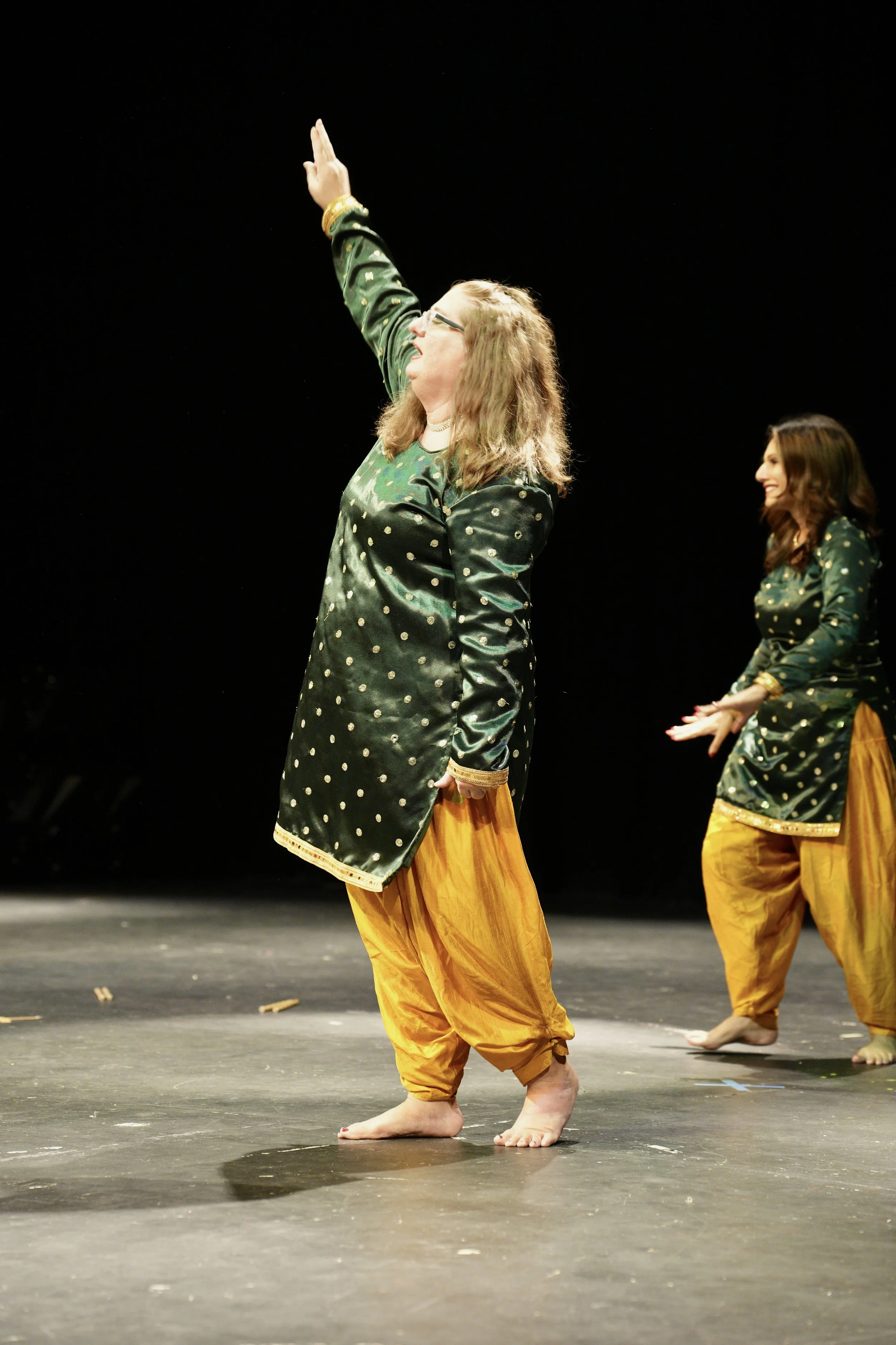 Adult dance group in stylish costumes on stage fall showcase