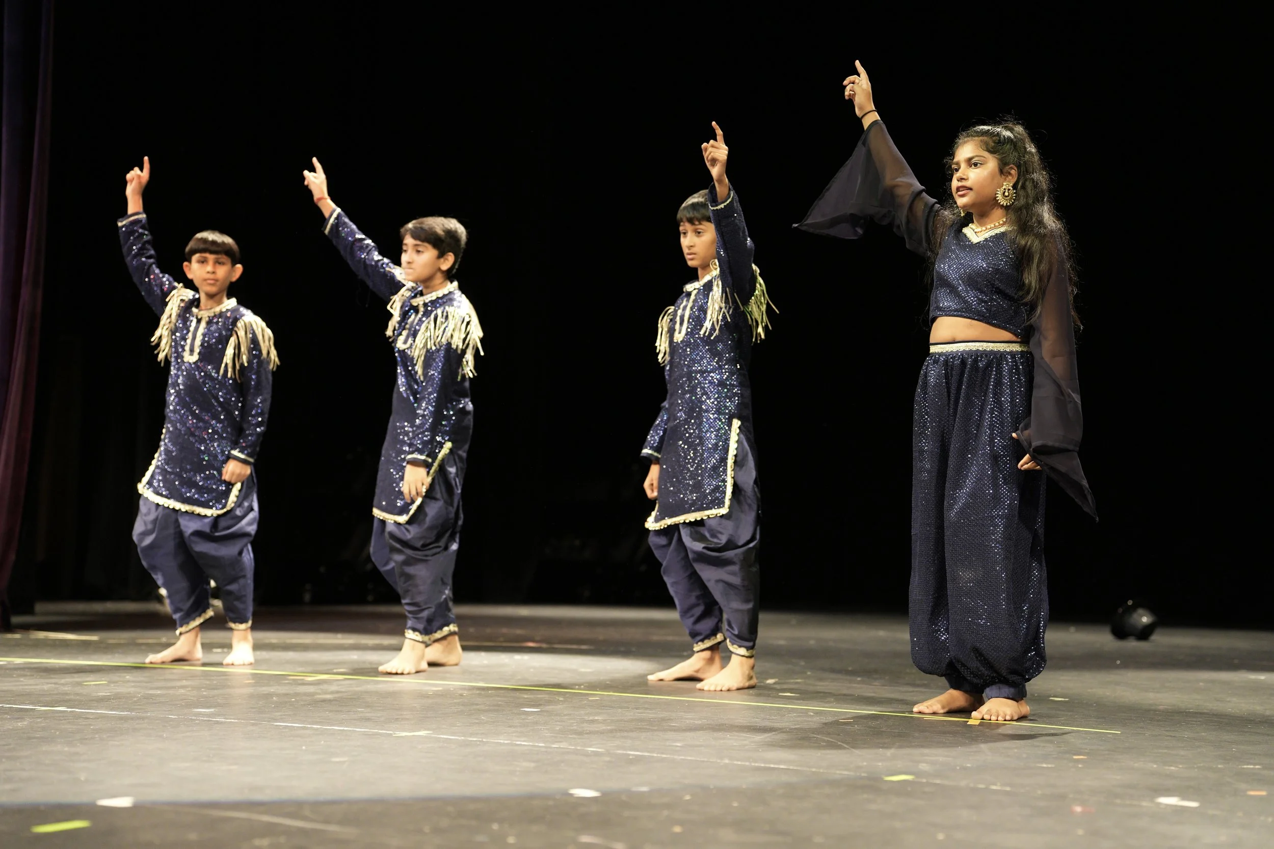 Teen dancers showcasing synchronized choreography at a fall dance recital performance