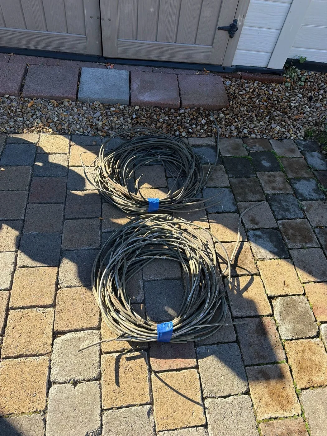 Two coils of old unconnected wire removed from house siding before exterior painting in Bend