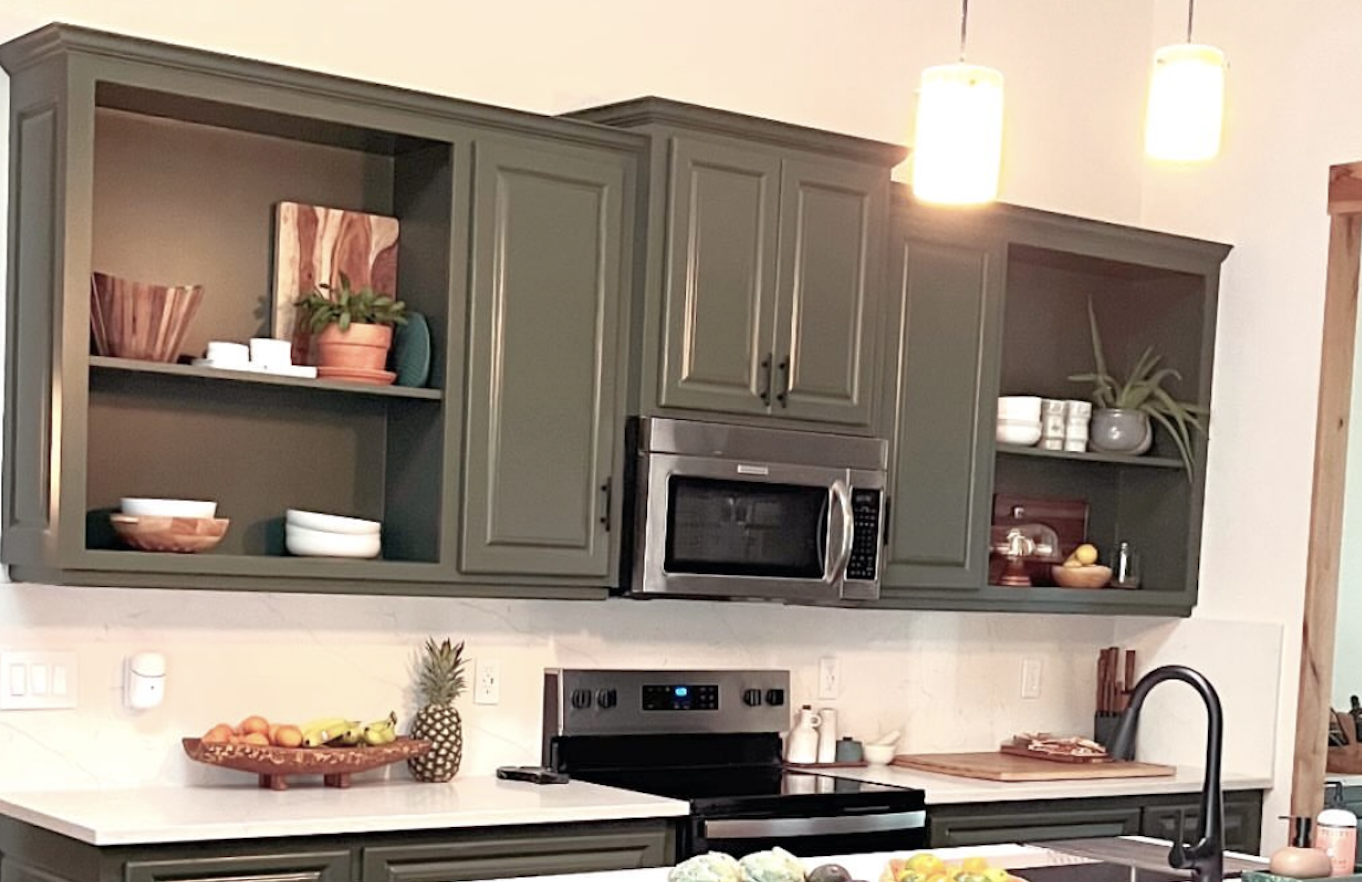 Modern kitchen with olive green shaker cabinets, white quartz countertops, stainless steel appliances, and open shelving, painted by Straight Edge Paint and Finish in Central Oregon.