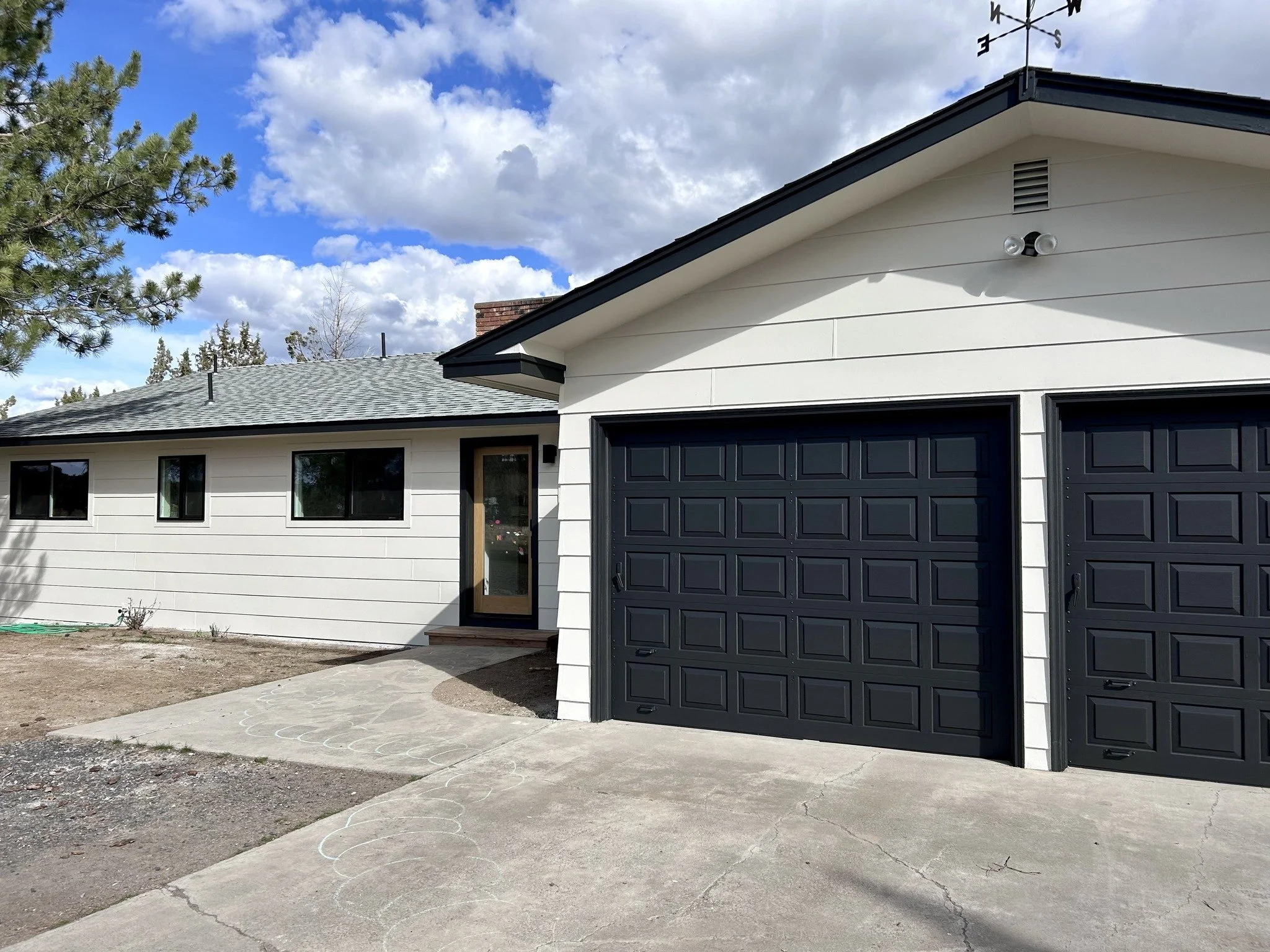Fresh exterior house painting in Bend Oregon featuring light gray siding with white trim and a welcoming front porch painted by Straight Edge Paint & Finish LLC