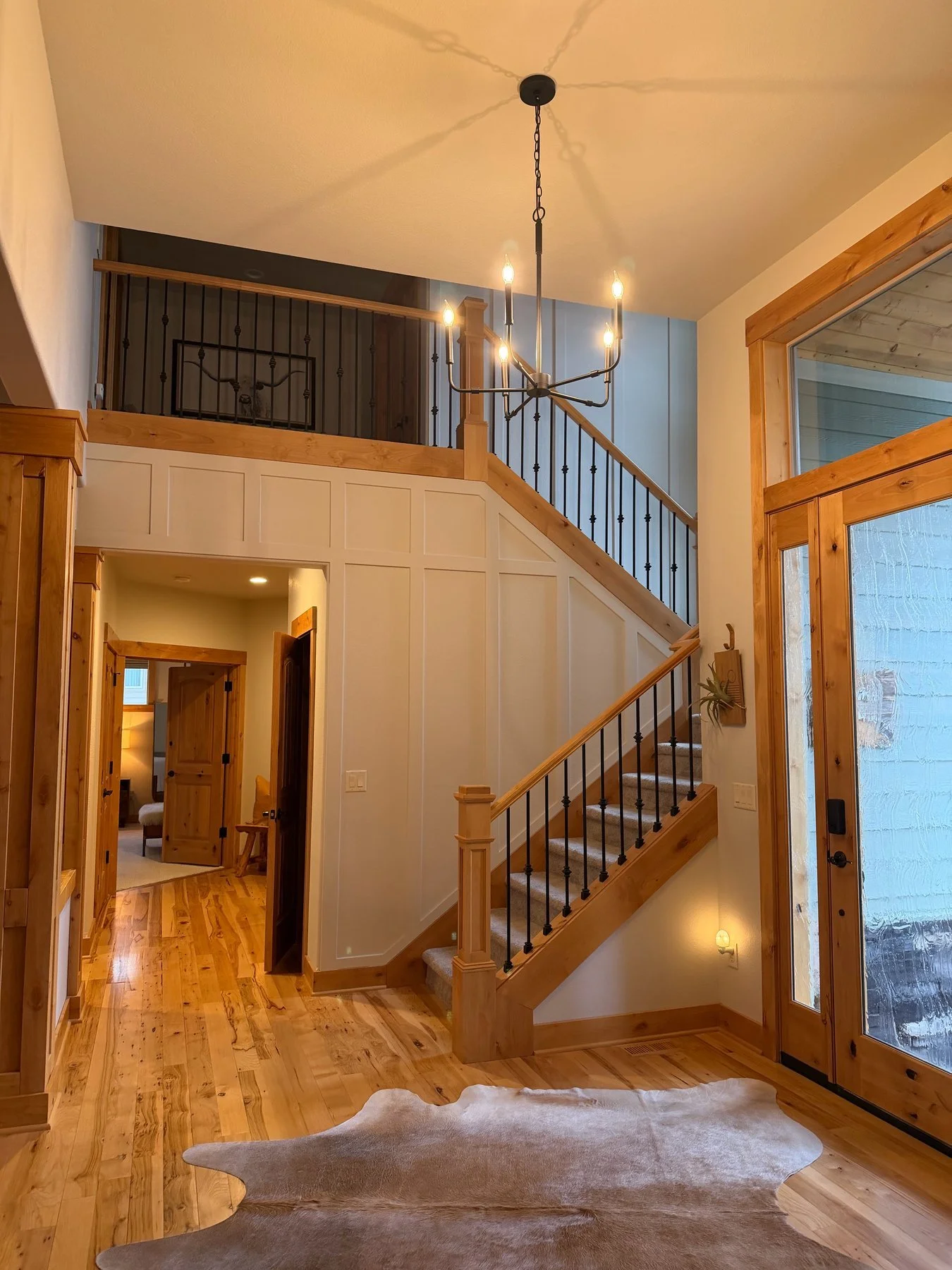 Board and batten stairway and wood entry in an Eaglecrest home after interior painting in Central Oregon