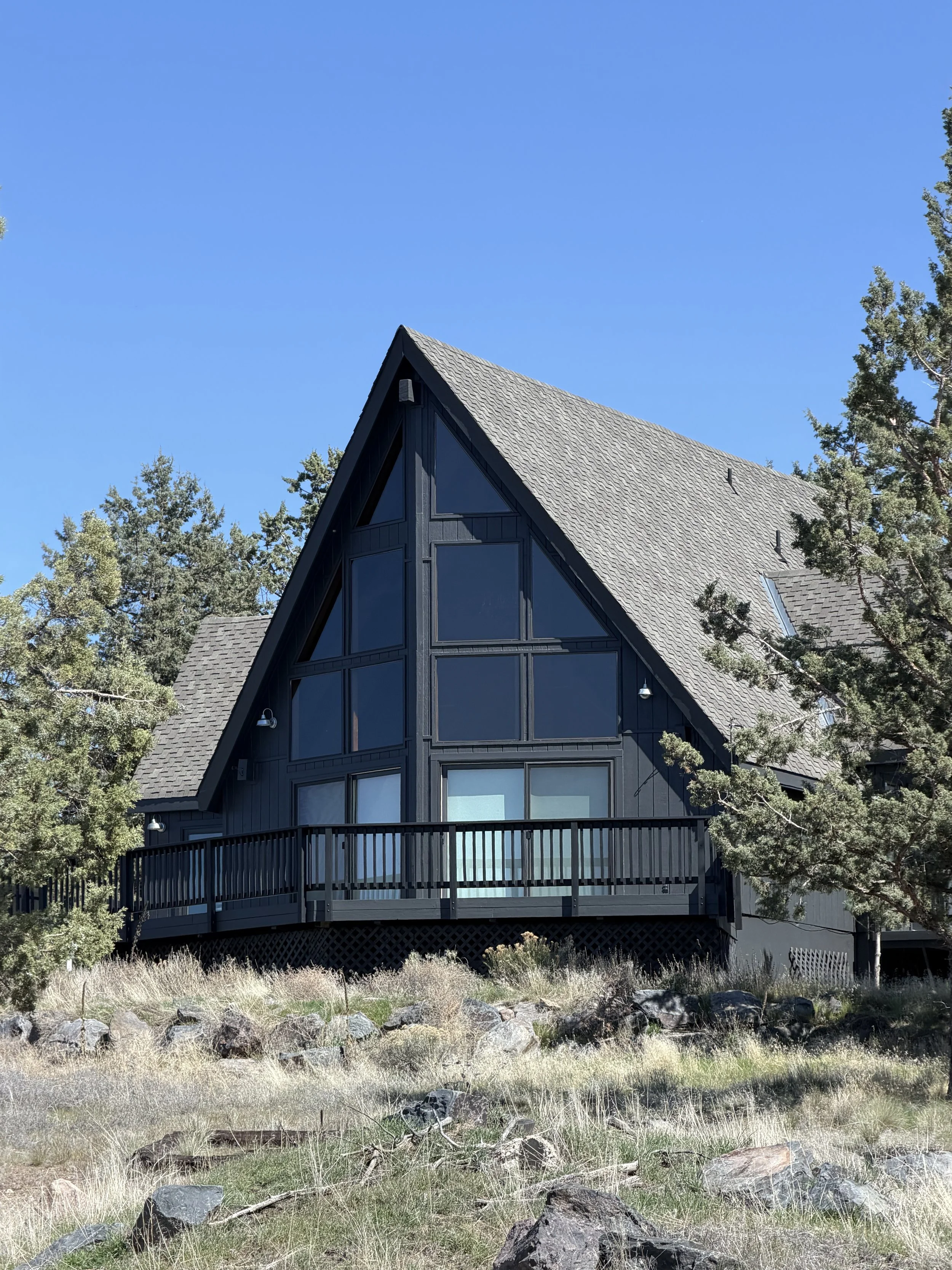 Dark exterior paint on an A-frame home in Central Oregon by Straight Edge Painting