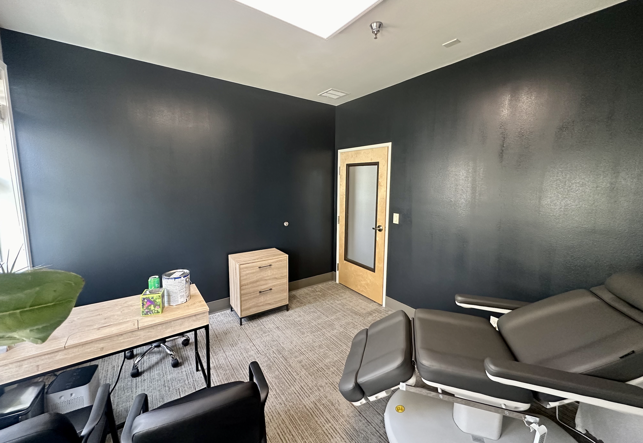 Freshly painted commercial office space with dark navy accent walls, light gray carpet, and modern furnishings, completed by Straight Edge Paint and Finish in Central Oregon.