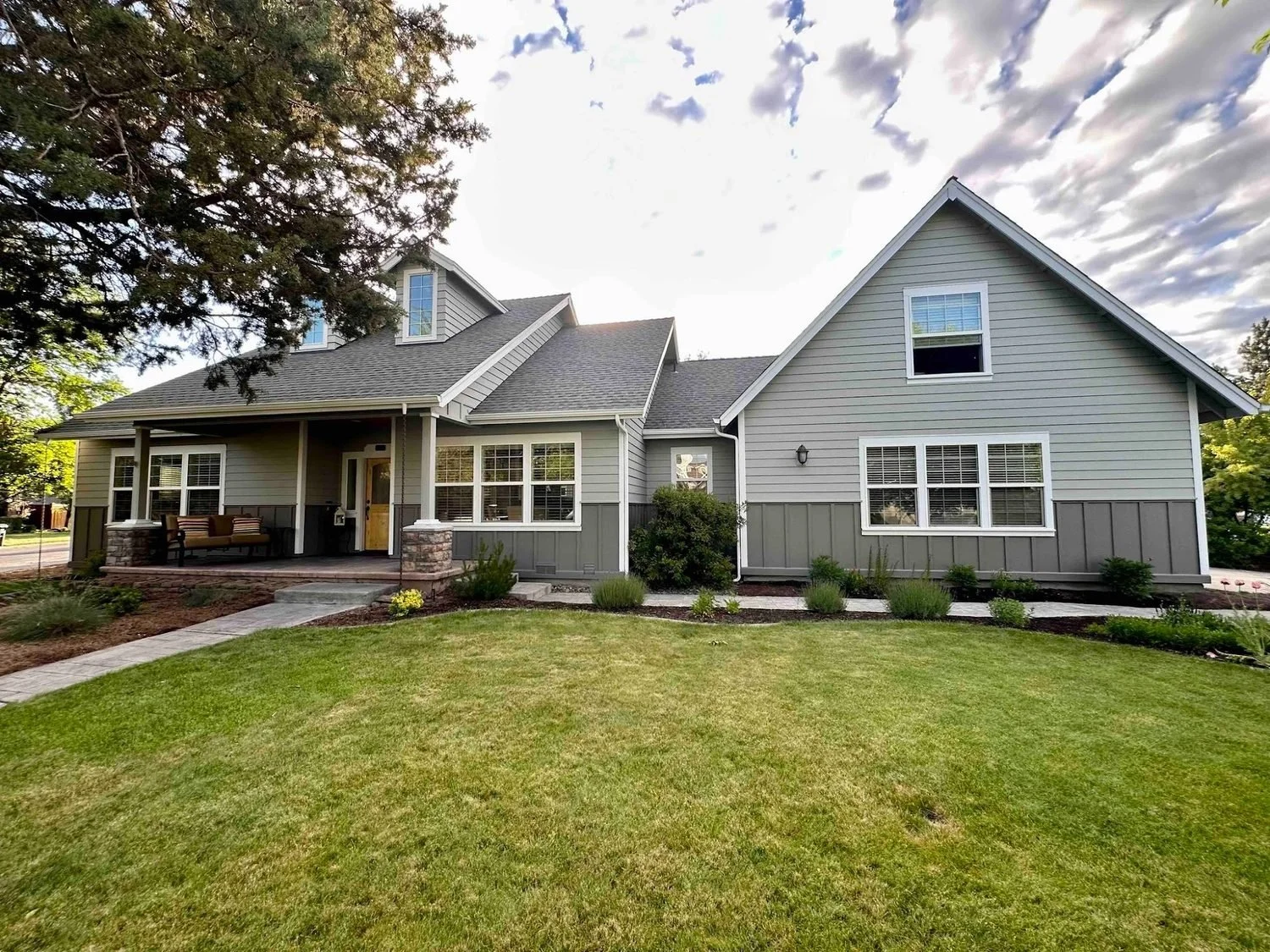 Modern exterior paint job in Prineville Oregon with white board and batten siding and dark shingle gables completed by Straight Edge Paint & Finish LLC