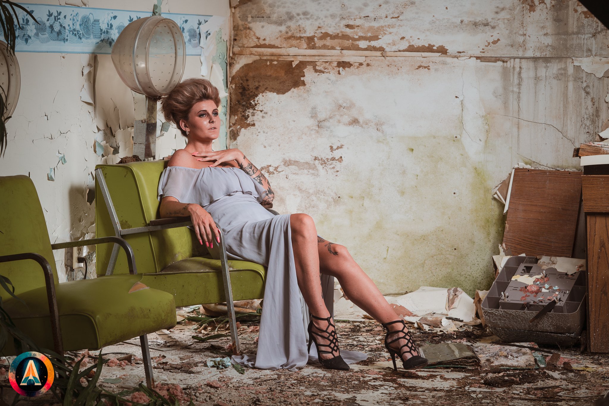 Blonde model courtney france poses in the haunted indiana state sanitarium shop / hair salon in a elegant blue dress.