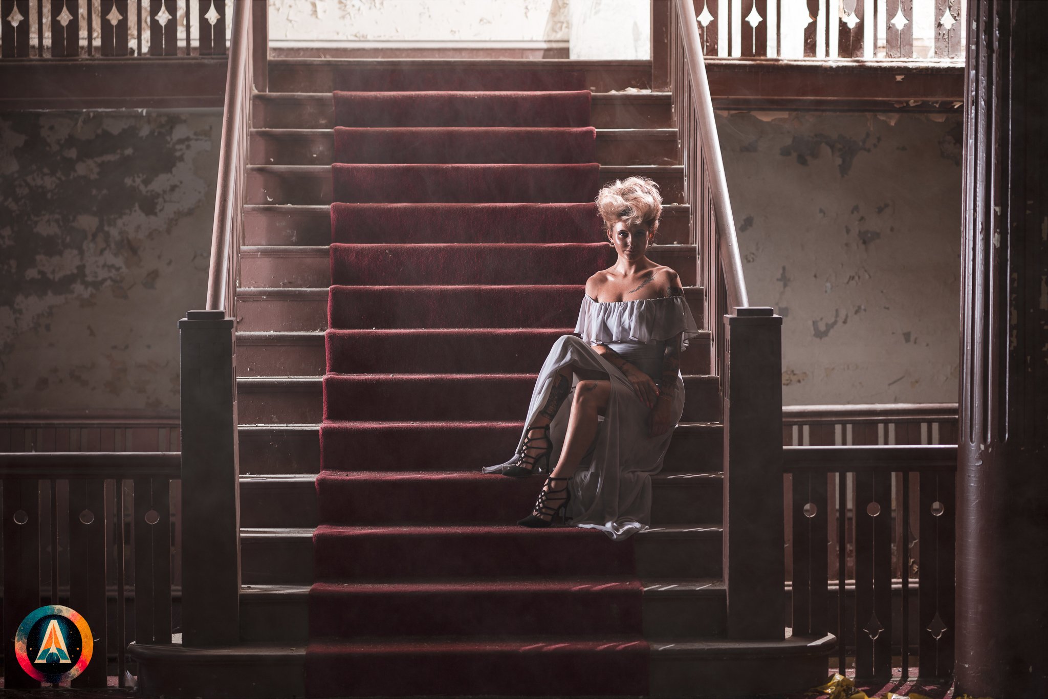 Blonde model courtney france poses in the haunted indiana state sanitarium shop / hair salon in a elegant blue dress.