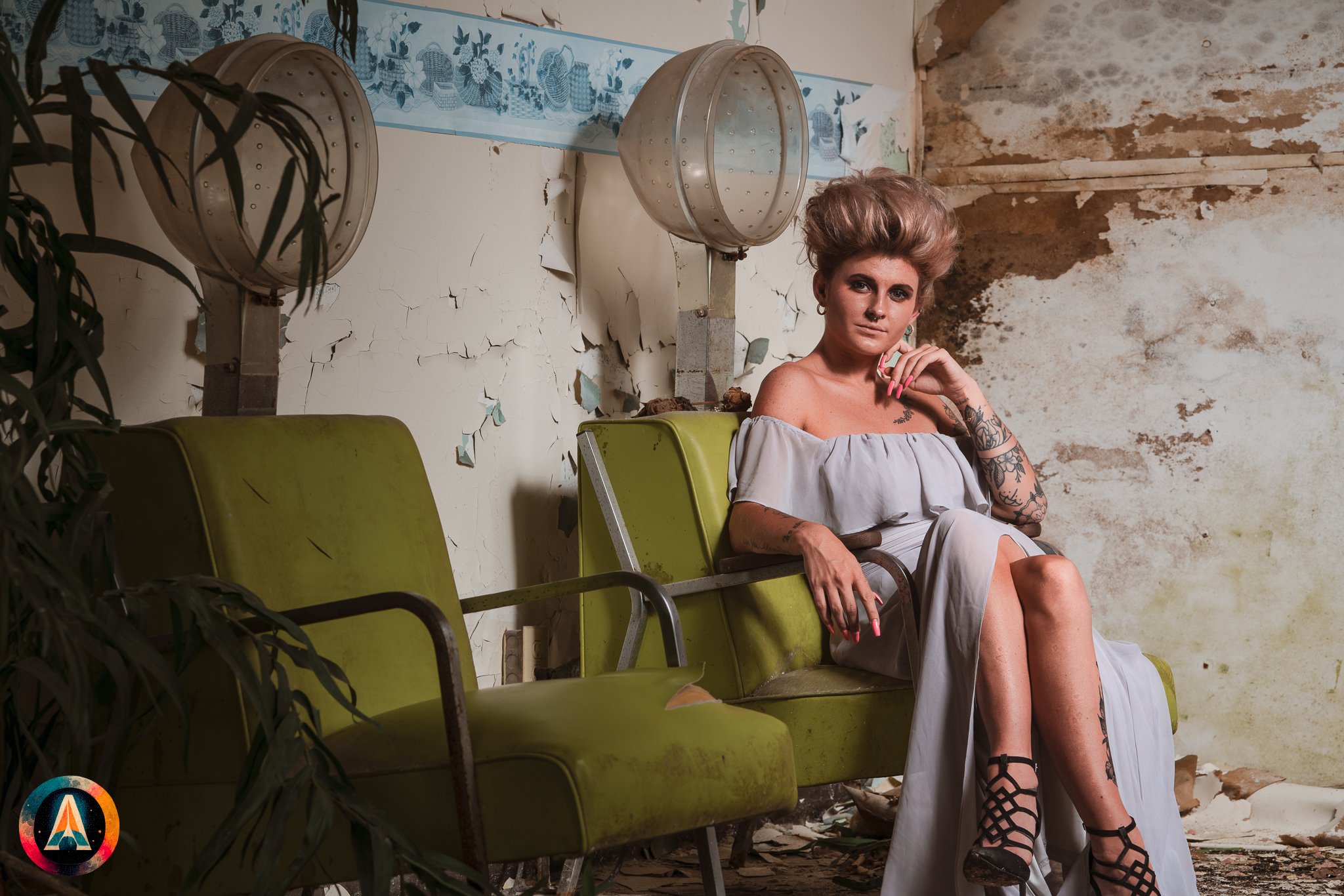 Blonde model courtney france poses in the haunted indiana state sanitarium shop / hair salon in a elegant blue dress.