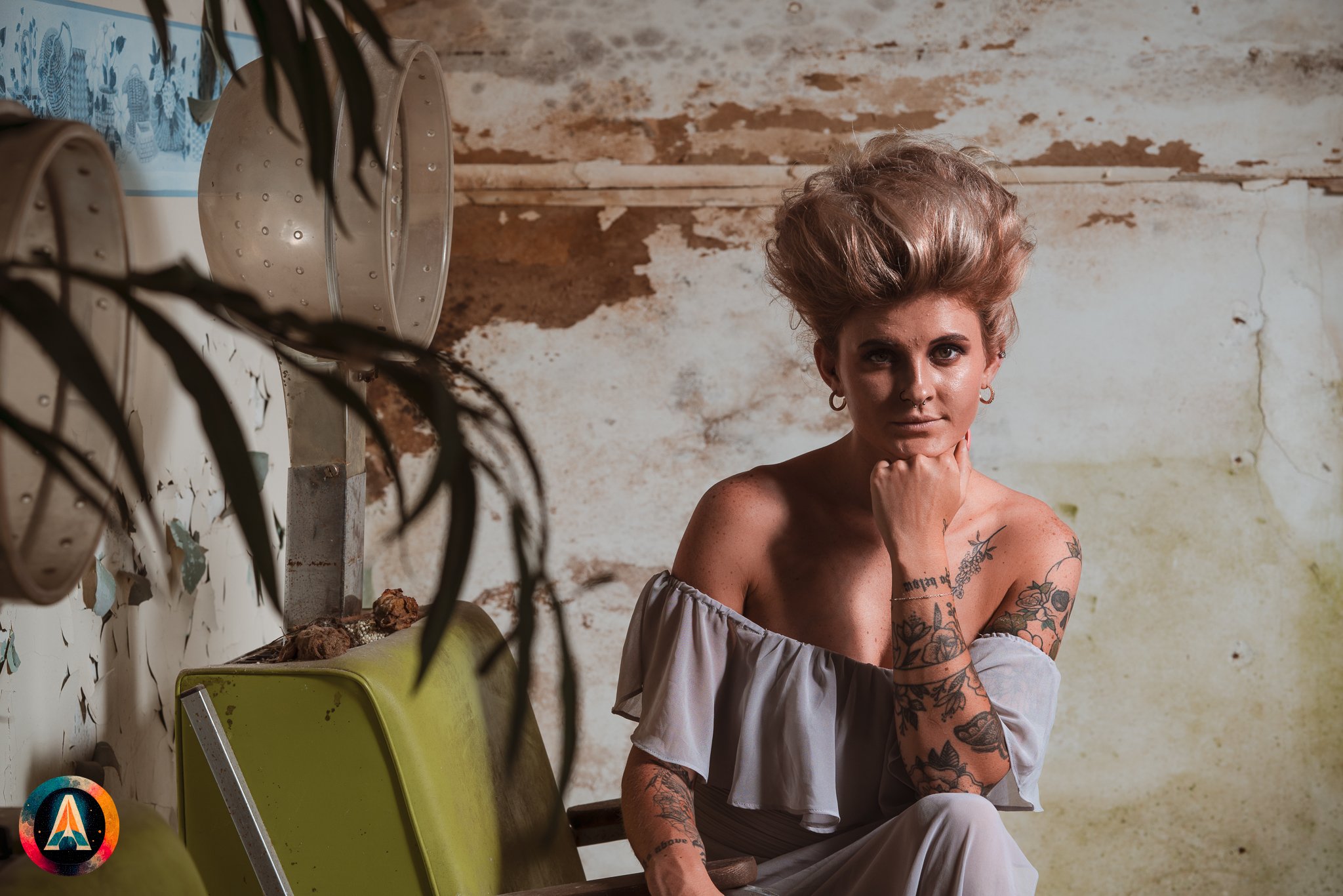 Blonde model courtney france poses in the haunted indiana state sanitarium shop / hair salon in a elegant blue dress.