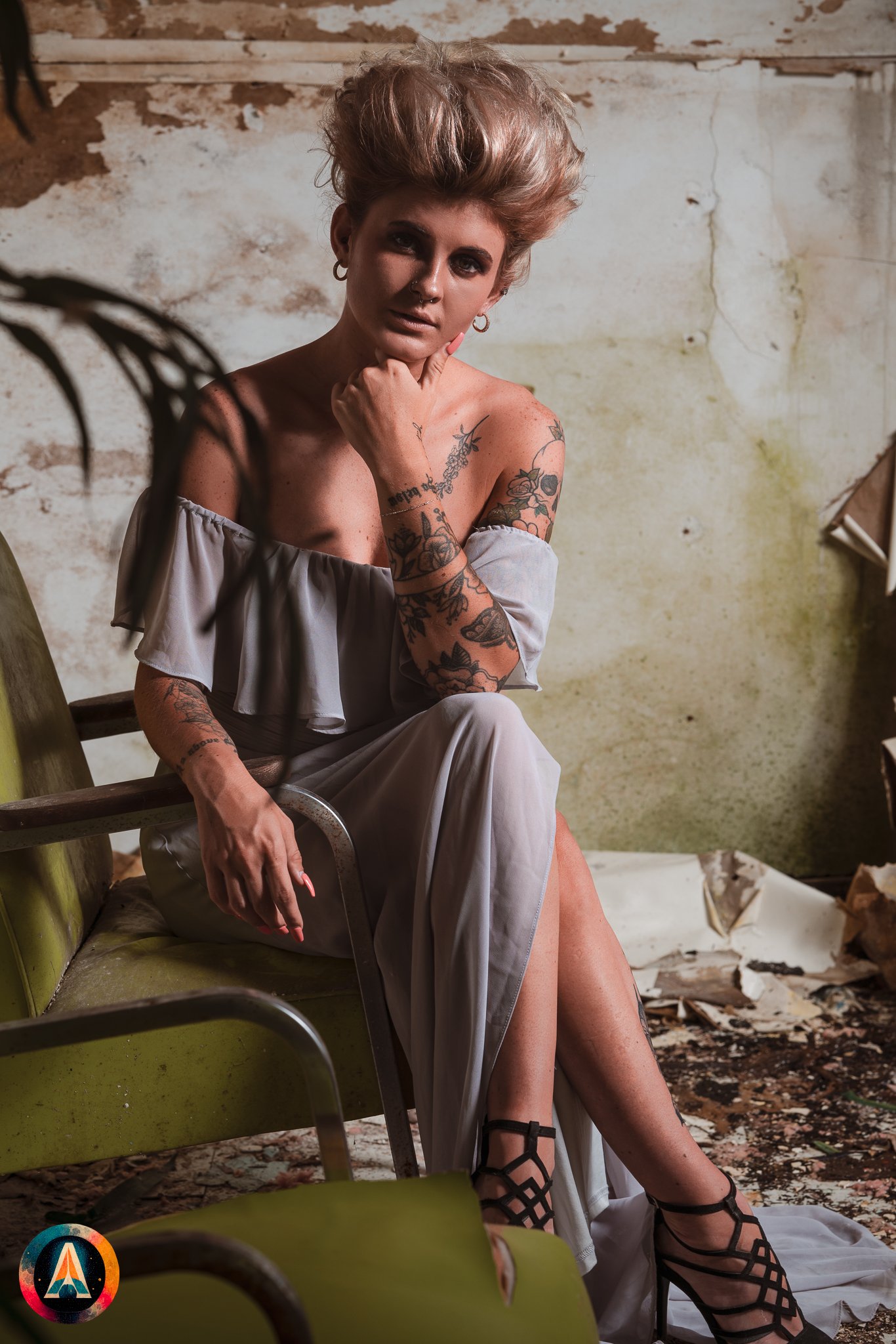 Blonde model courtney france poses in the haunted indiana state sanitarium shop / hair salon in a elegant blue dress.