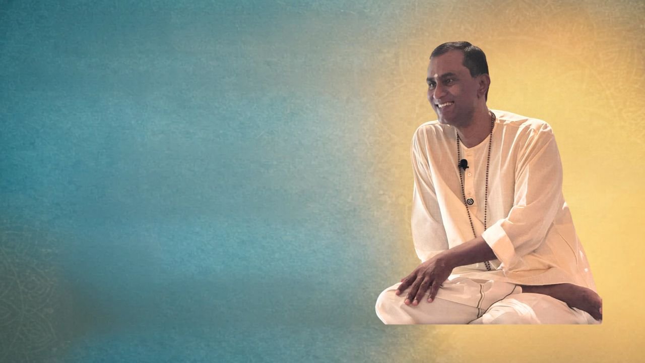 Woman in a red shirt meditating indoors with hands in prayer position.