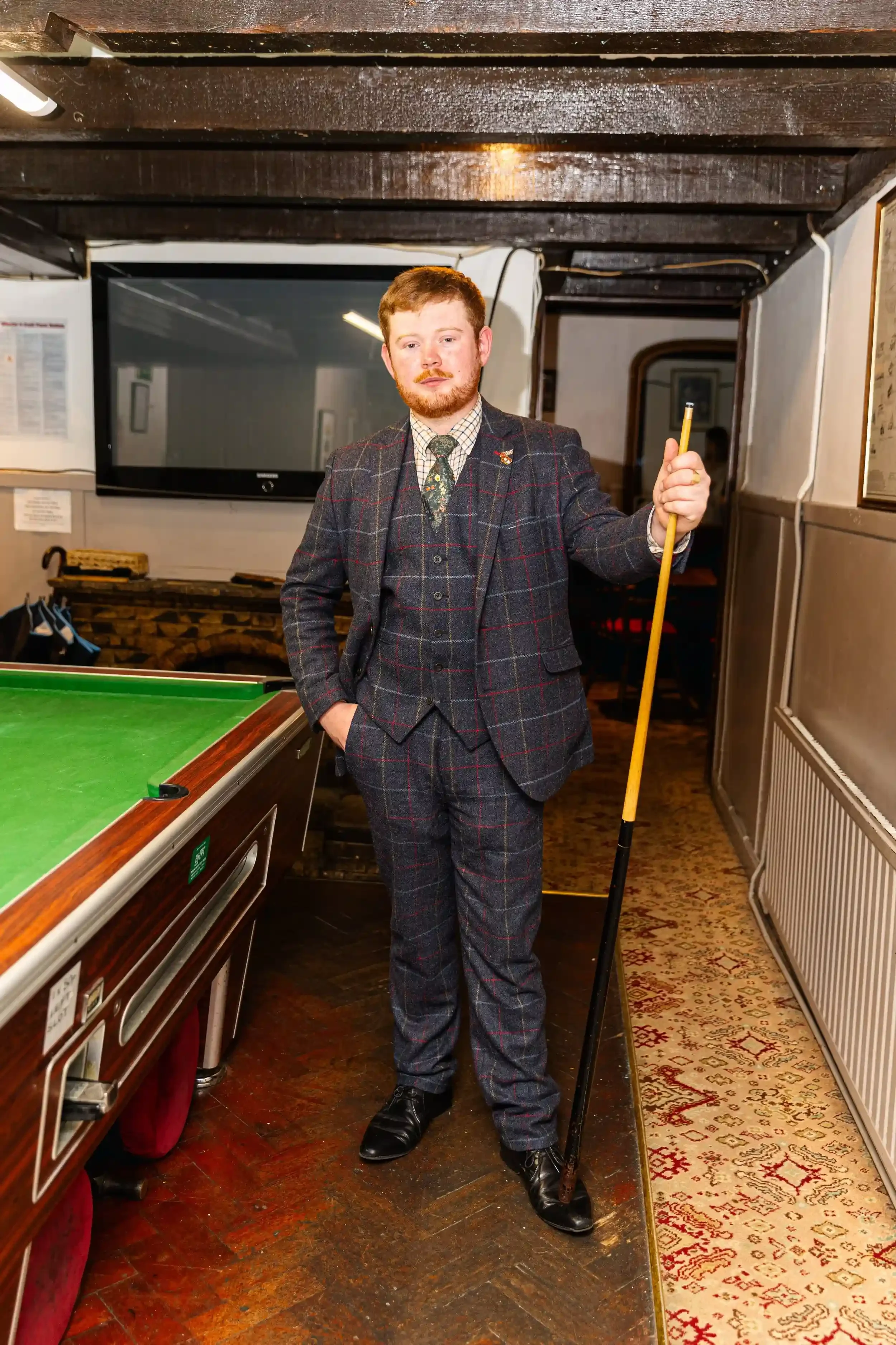 James Faull wearing a tweed suit and holding a pool cue at the Seaview Inn, from Matthew Morgan's 'Proper Pub' project.