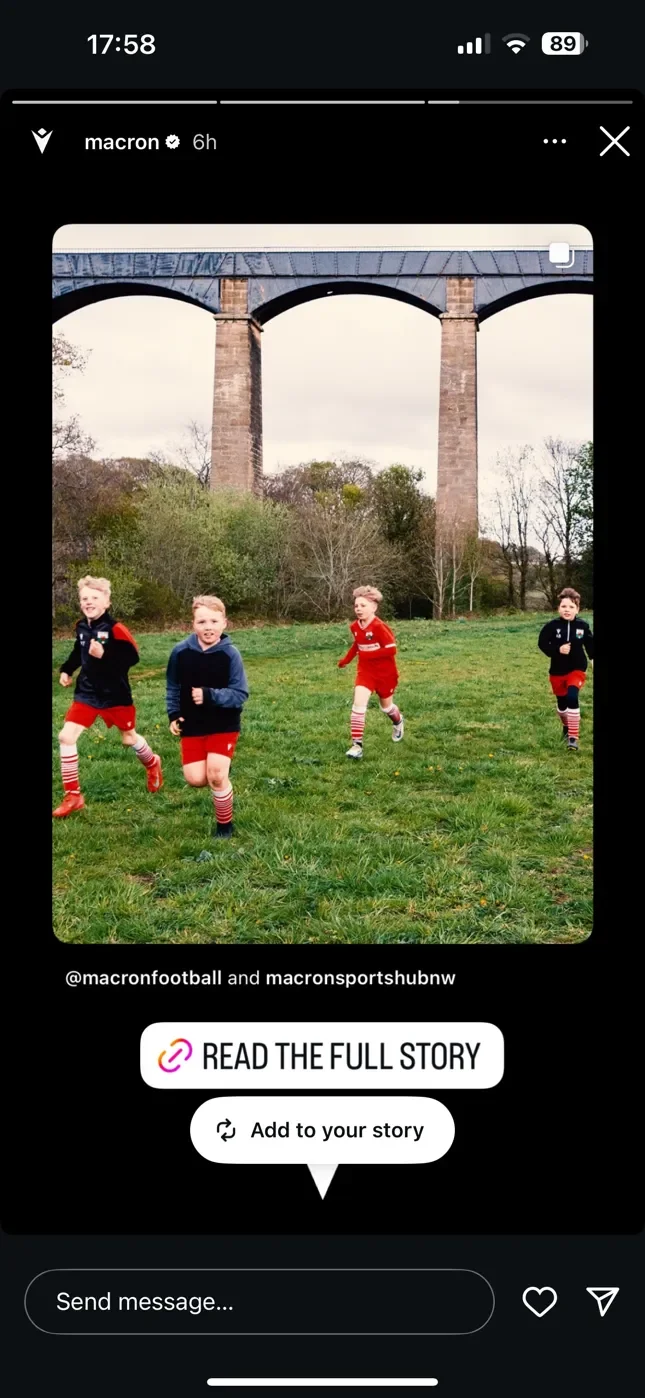 A screenshot of a Macron Instagram story featuring a photo by Matthew Morgan. The image shows four young Chirk Youth FC players running on a grass pitch with the massive arches of the Pontcysyllte Aqueduct in the background. A 'READ THE FULL STORY' b