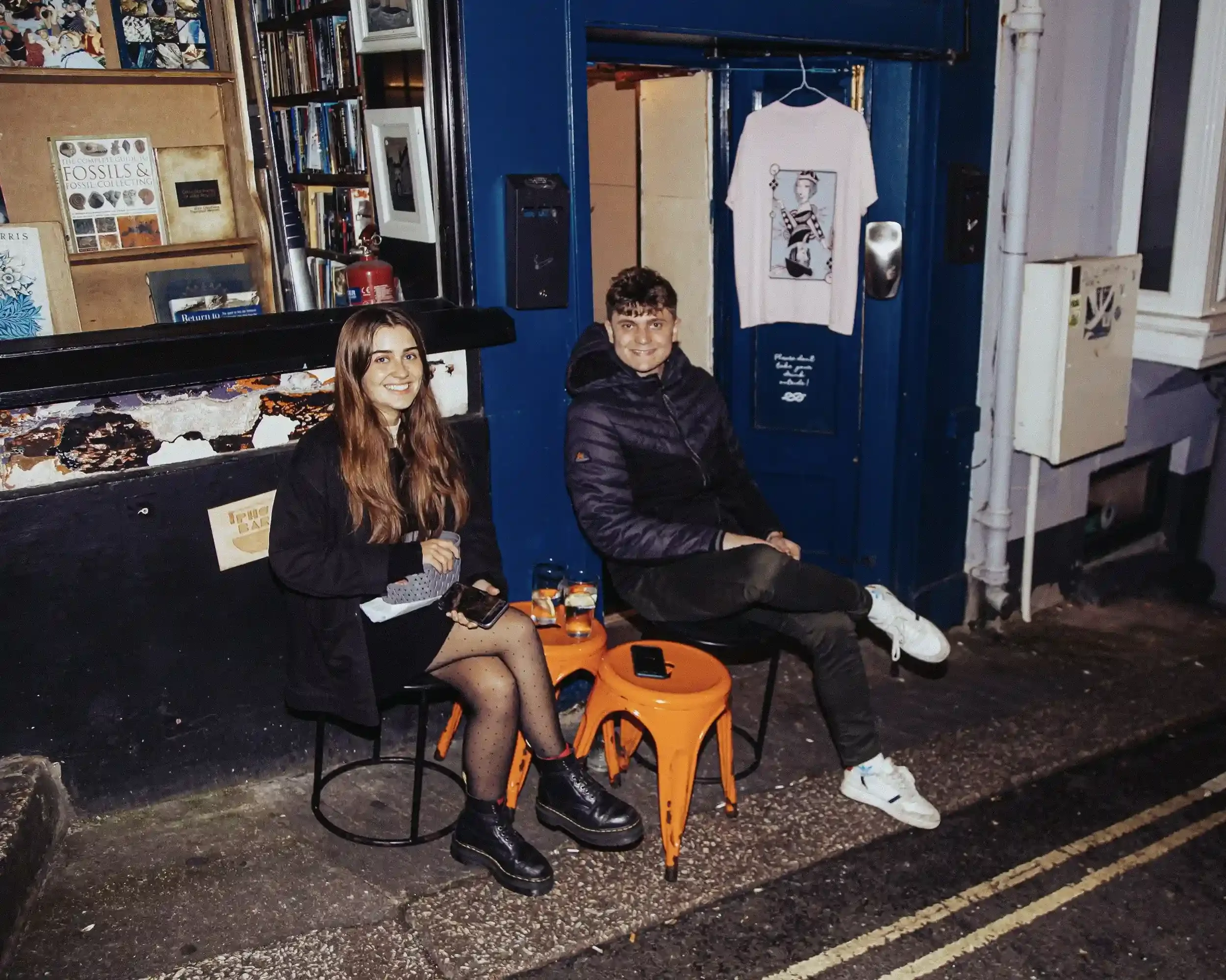 Candid hospitality photography by Matthew Morgan at Small Ships bar. The image features the door team smiling and socialising outside the venue during a charity fundraiser. The high-contrast flash and urban setting highlight the friendly, professiona
