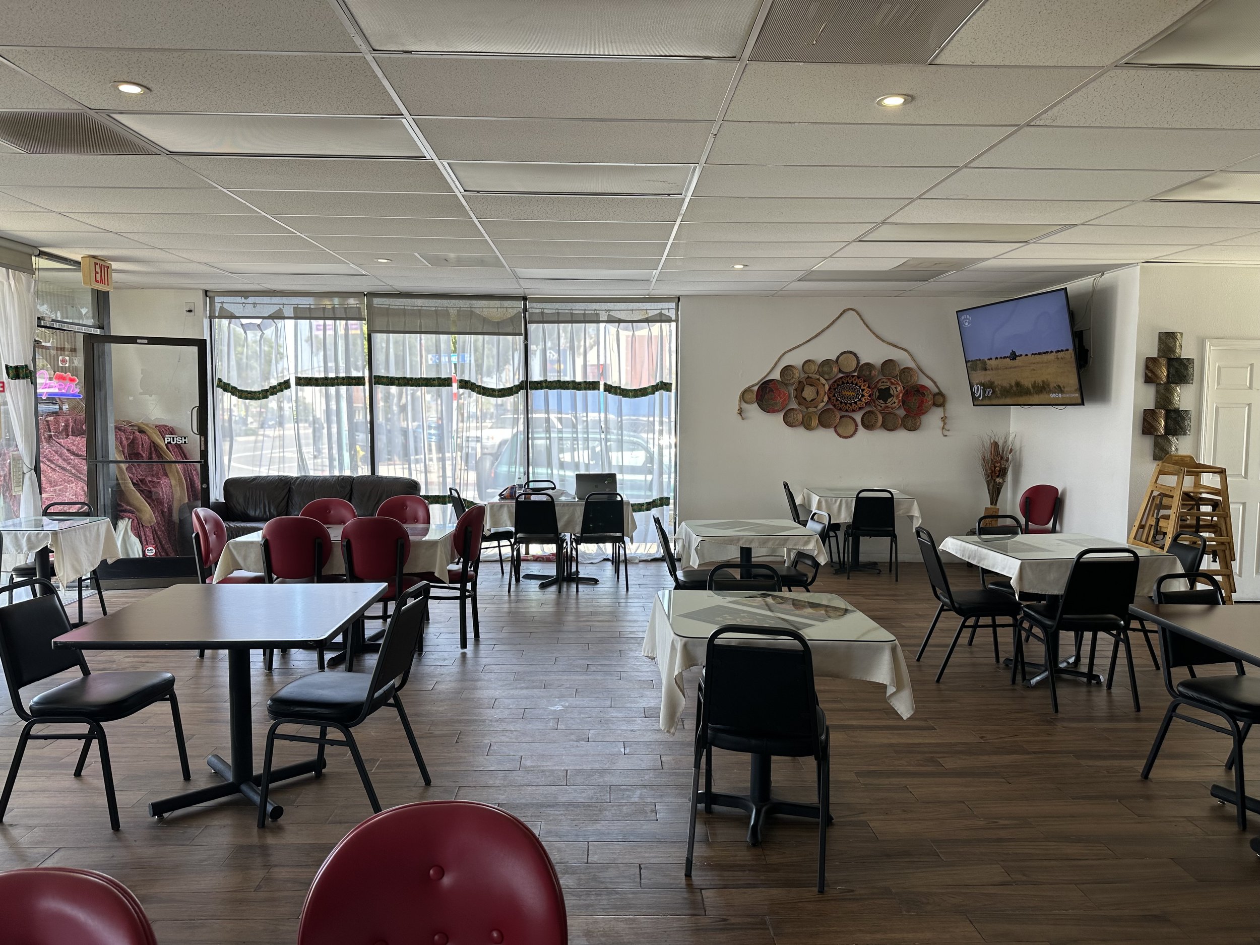 BEFORE — Ordinary banquet chairs, tables, white ceiling tiles and fluorescent lights overpowered thoughtful cultural decor