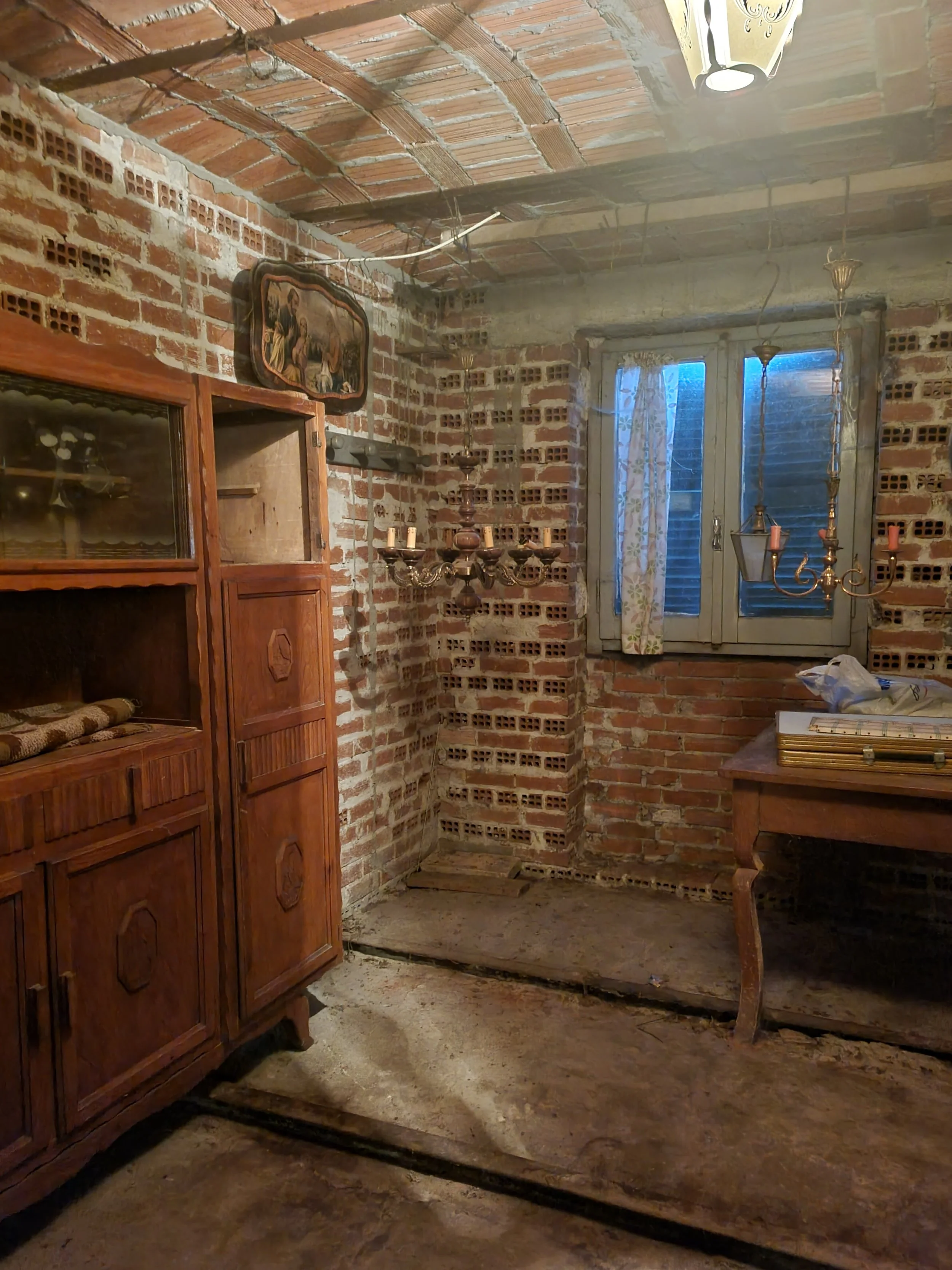 Interior of an old cascina in Piemonte filled with inherited belongings before renovation.