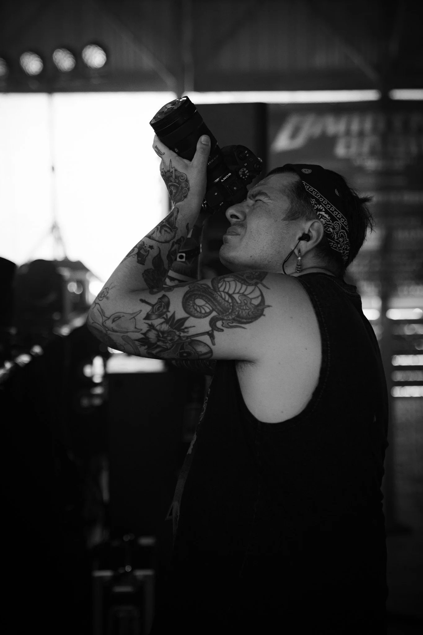 Behind the scenes image of a photographer framing a live performance inside a concert venue.