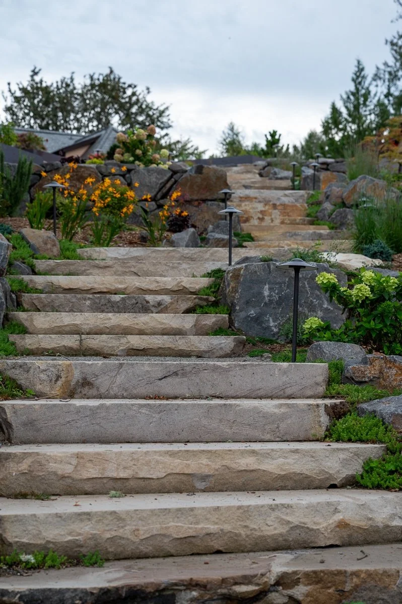 Large stand stone staircase with plants surrounding it.