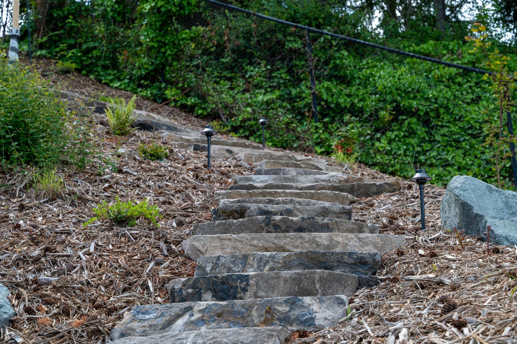 Stone staircase with pathway lights on along the edges.