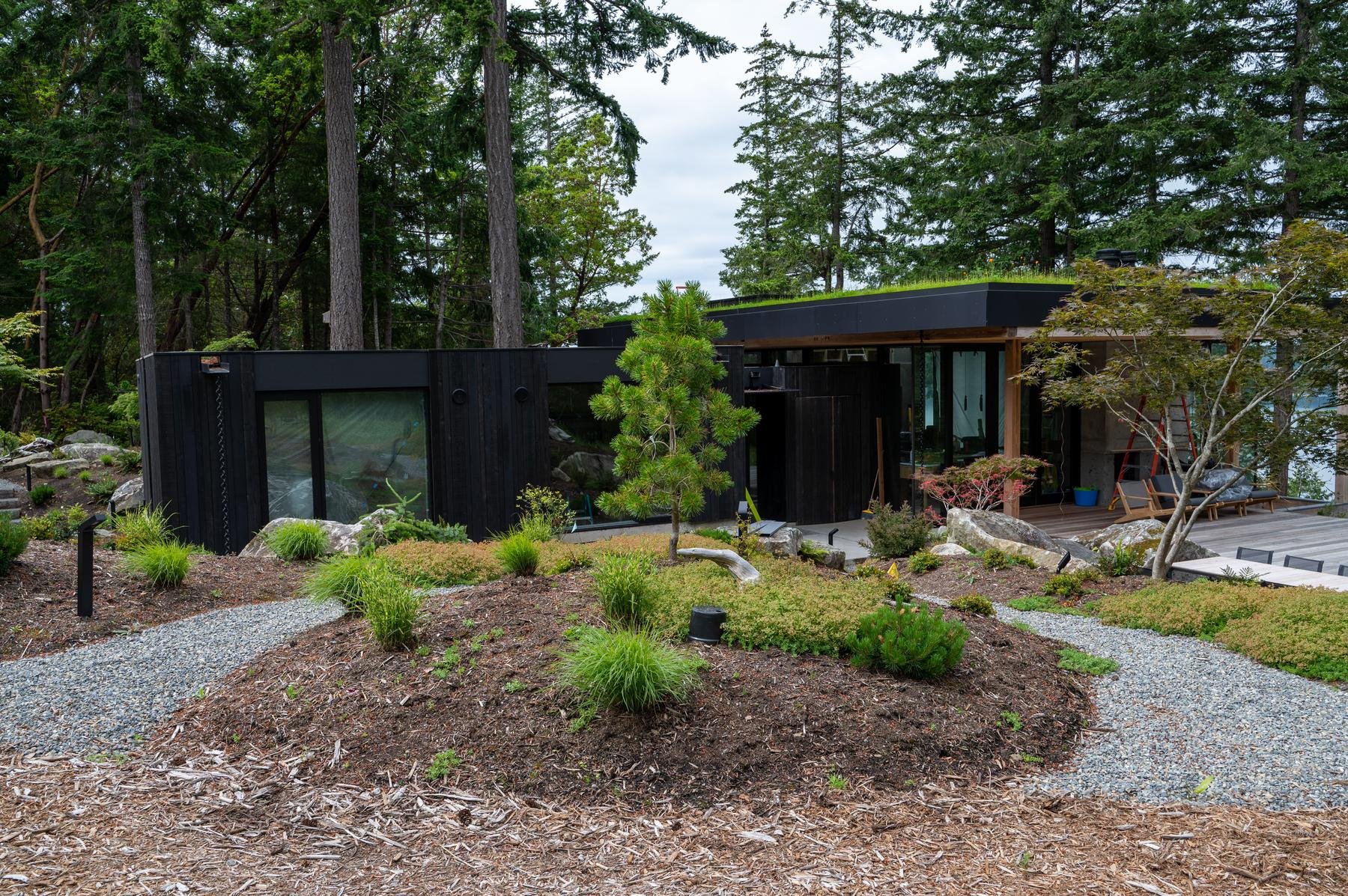 Black and concrete modern home with black LED path lights.