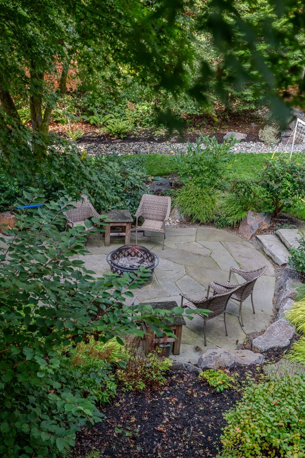 Stone steps leading to a stone walkway with a green lawn and a slate patio 1.jpg