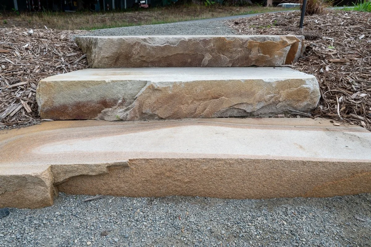 Sandstone stairs with bark on the sides.