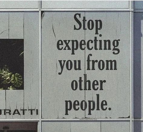 Large sign on a building with the text 'Stop expecting you from other people.'