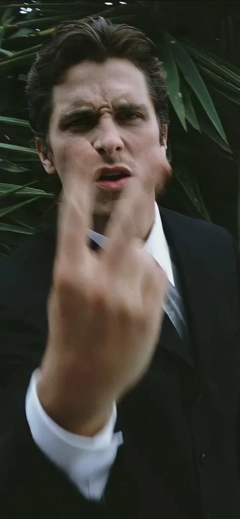 Man in suit making hand gesture outdoors