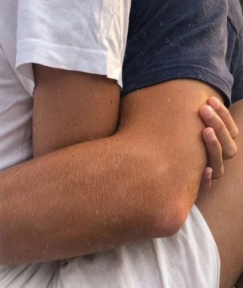 two people hugging, wearing white and blue shirts