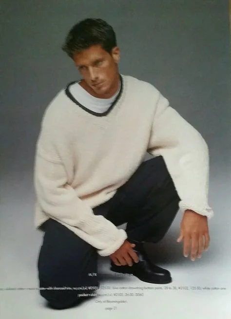 Person wearing white sweater and black pants kneeling