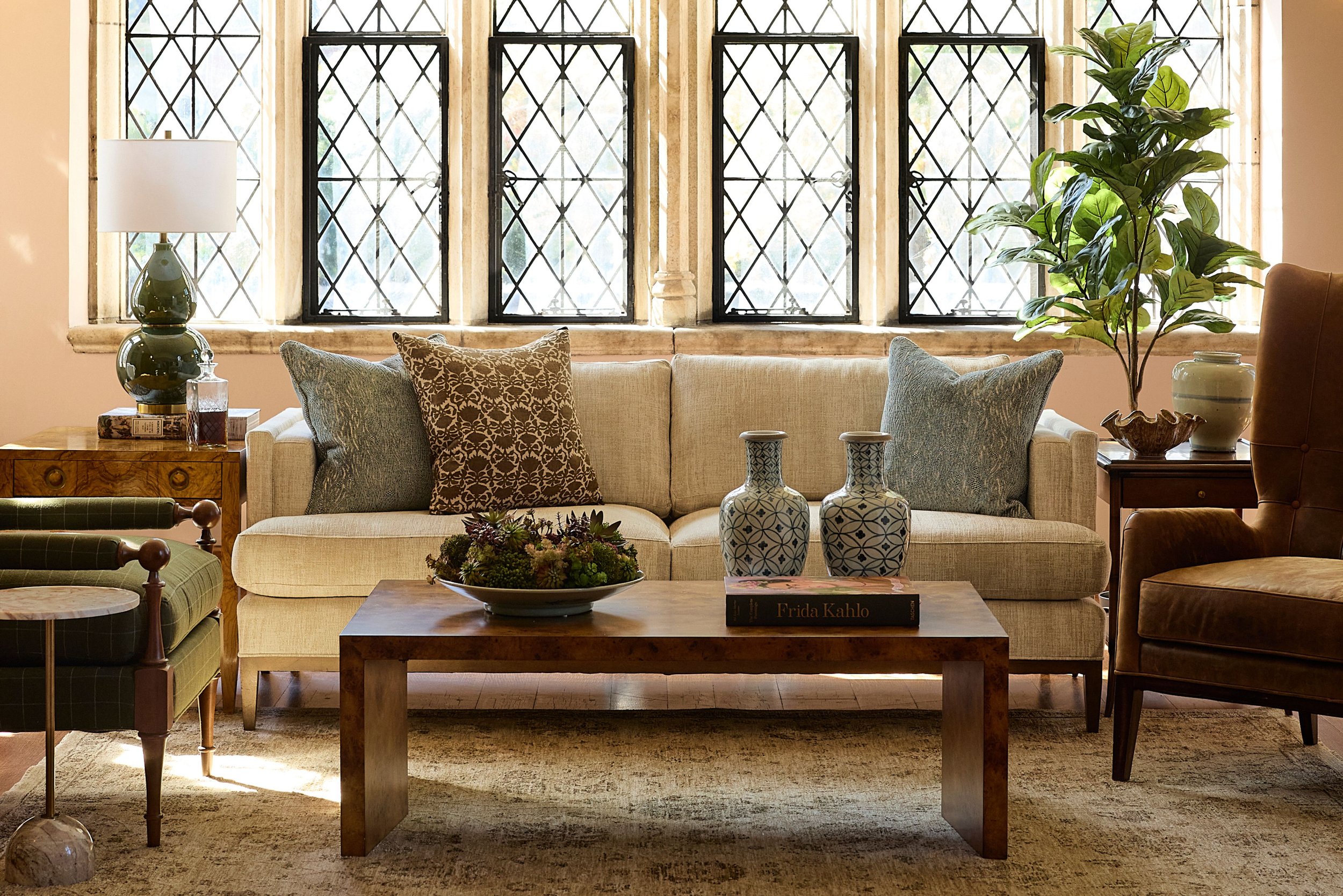 A styled living room with custom upholstery, a coffee table, pillows and pottery. Styled at the Branch Museum in Richmond, Virginia.