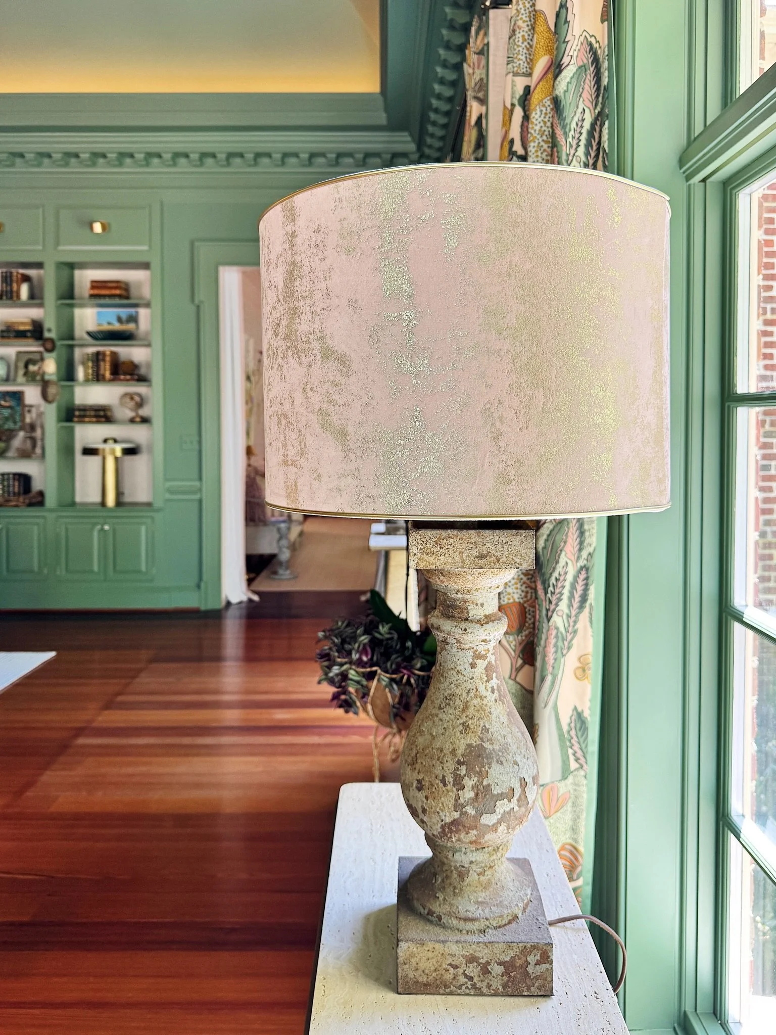 Every detail in the Living &amp; Dining Room at @foundrymanor was chosen with intention, right down to the lampshades. Our designers worked with @lamplitatelier to create custom shades in the prettiest blush and gold fabric, finished with a hand sele