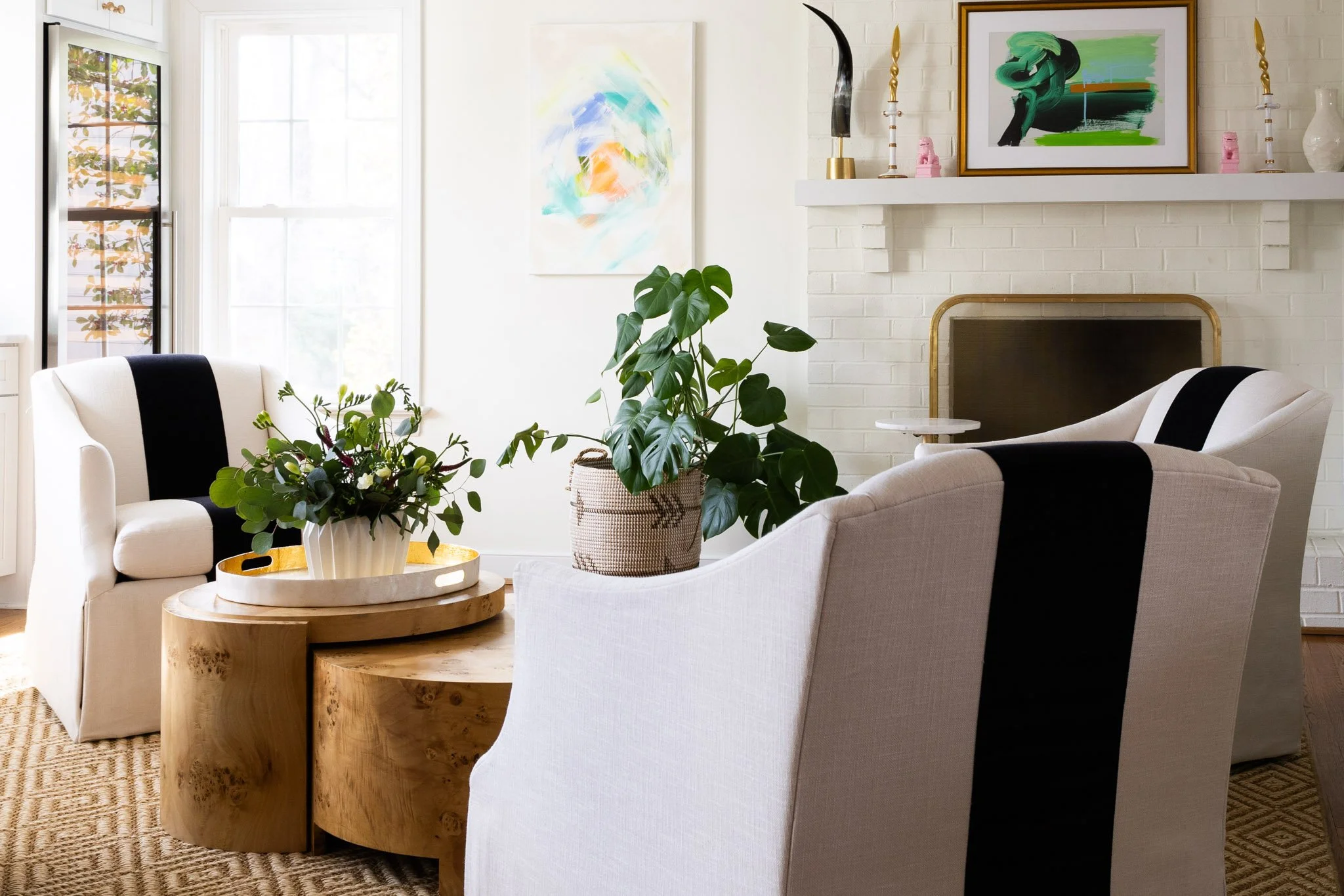 A set of Lee swivel chairs upholstered in bold black and white arranged around a central coffee table in a bright living space.