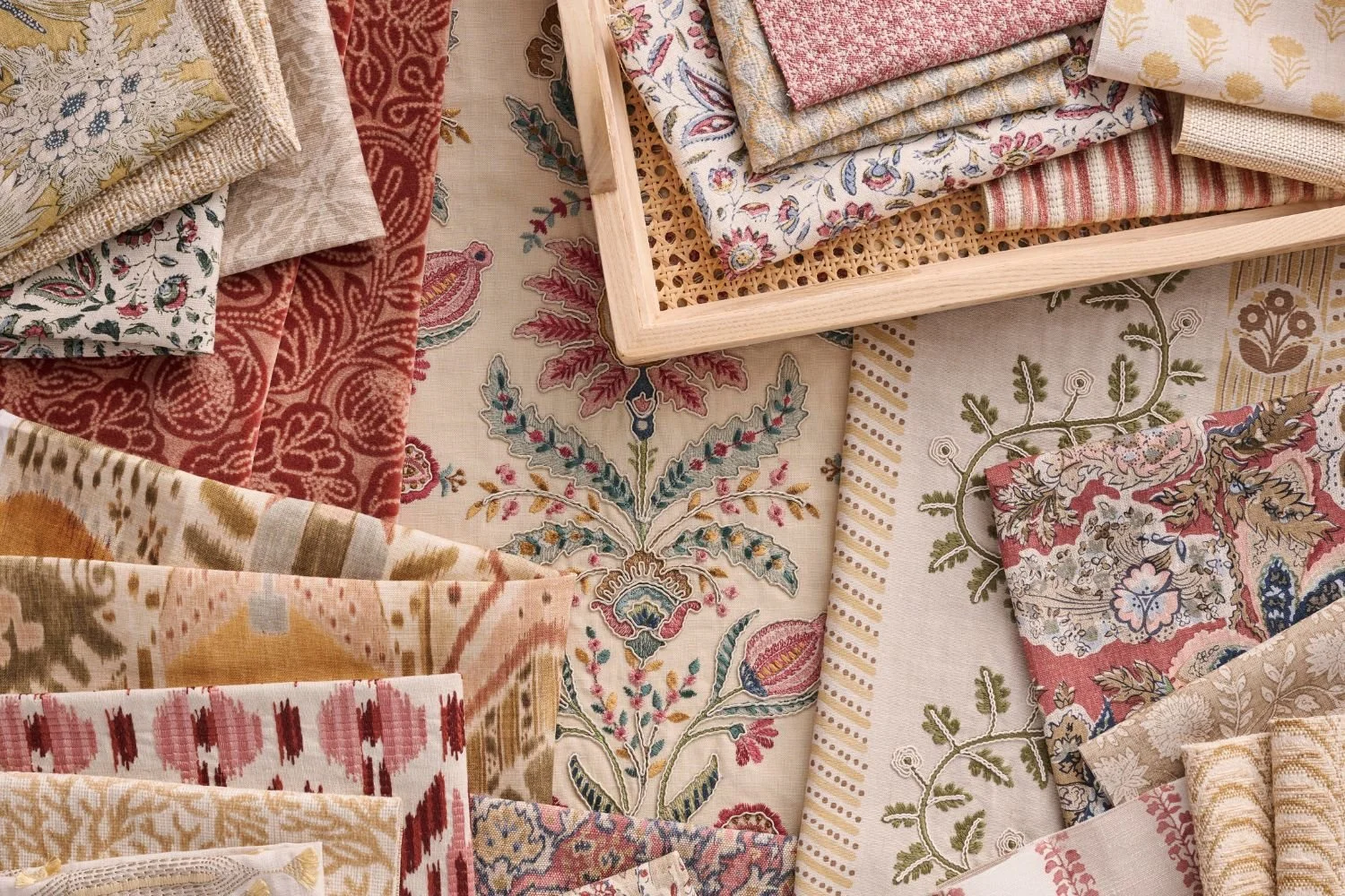 Close-up of Stroheim’s latest fabric collection featuring rich florals, block prints, and textured textiles in warm, saturated tones.